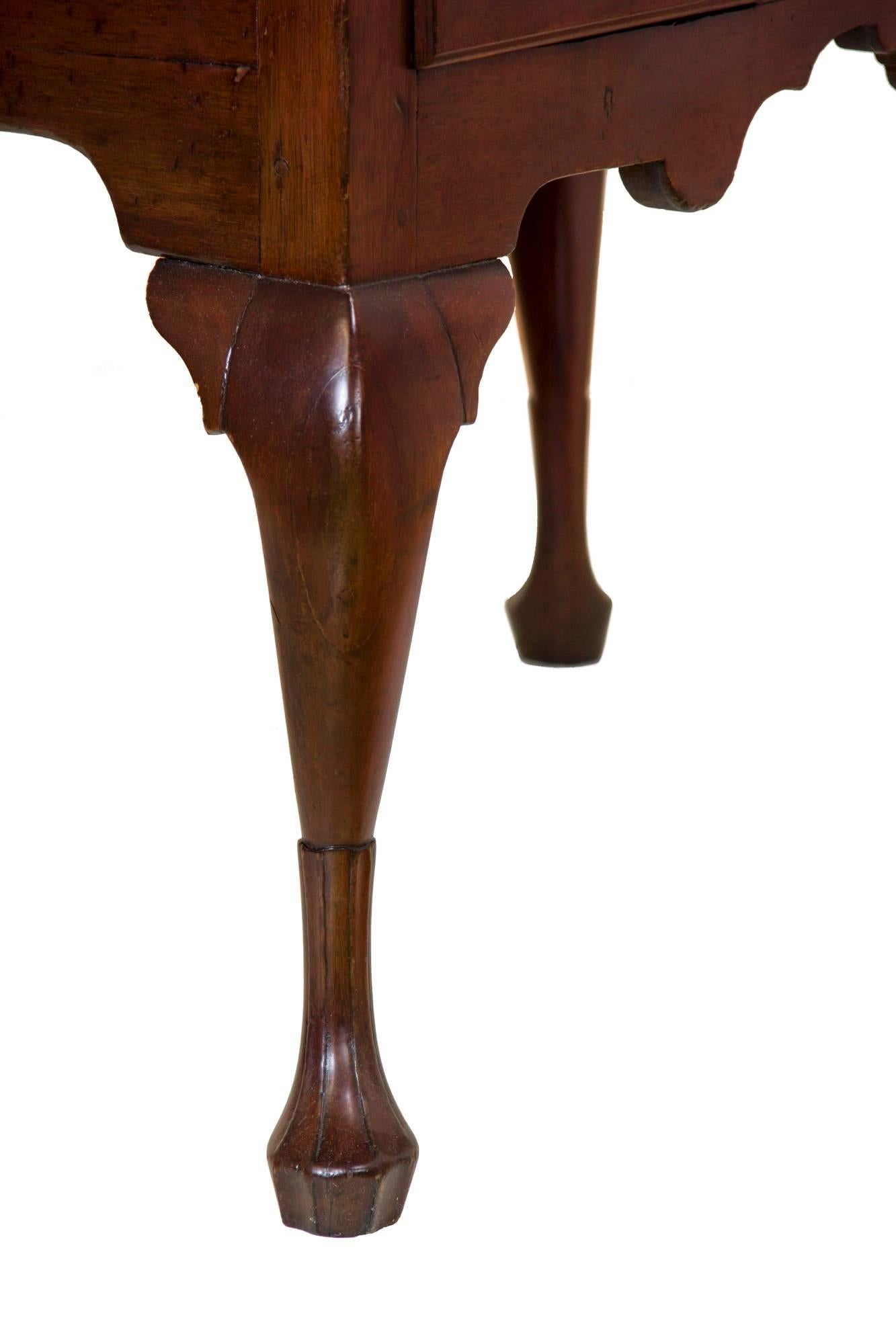 This lowboy is composed of fine, dense, heavy island (Cuban) mahogany and has a solidness with a finely sculptured and traditional base skirt, all of which is supported on beautifully sculpted Queen Anne legs with stocking feet. Note the strong