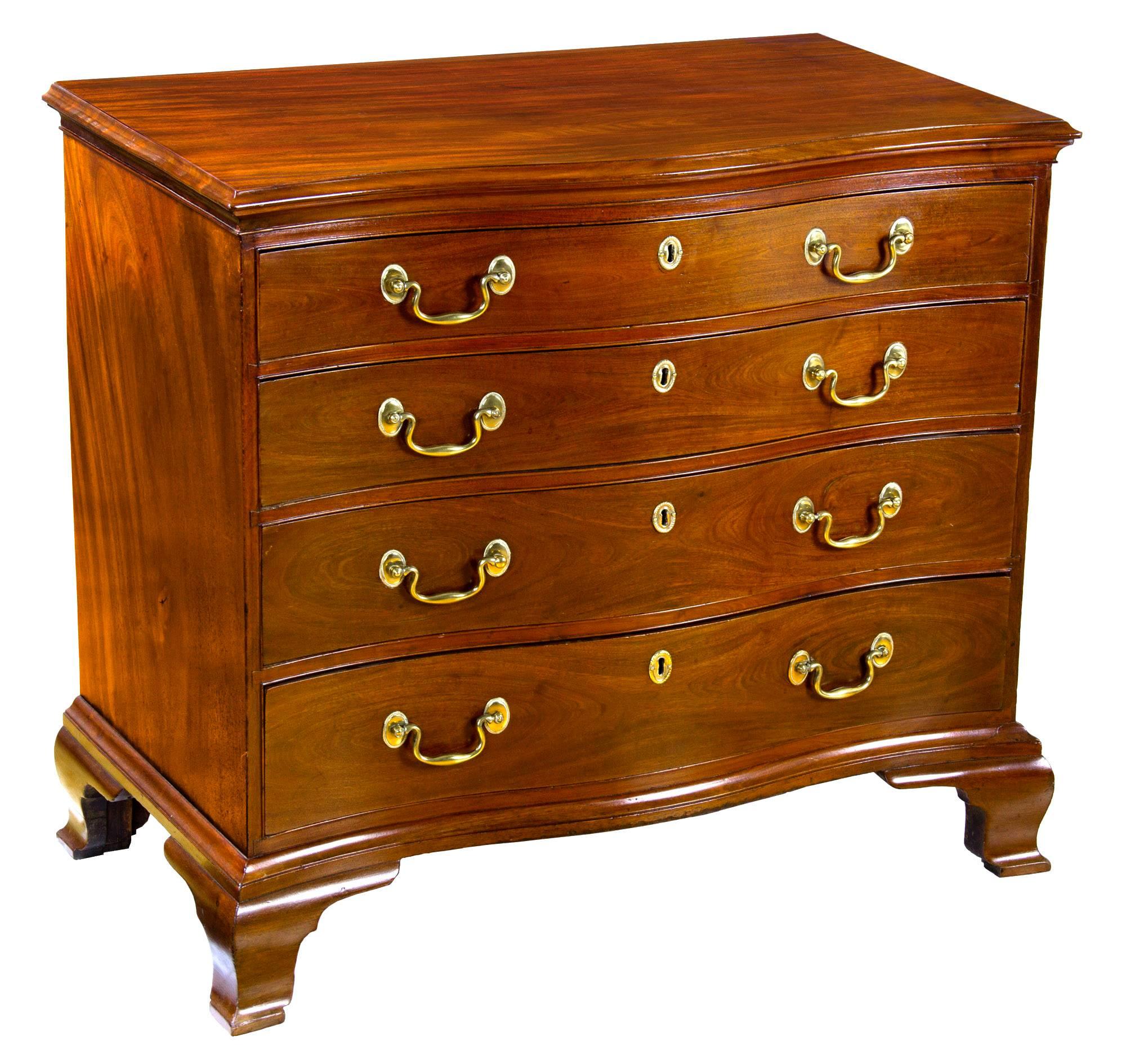This serpentine bureau is composed of strongly figured dense Cuban mahogany. The drawer fronts are carved out of solid logs and all surfaces, i.e. the top and sides, are strongly figured and vibrant. (See attached images of the top and sides.)