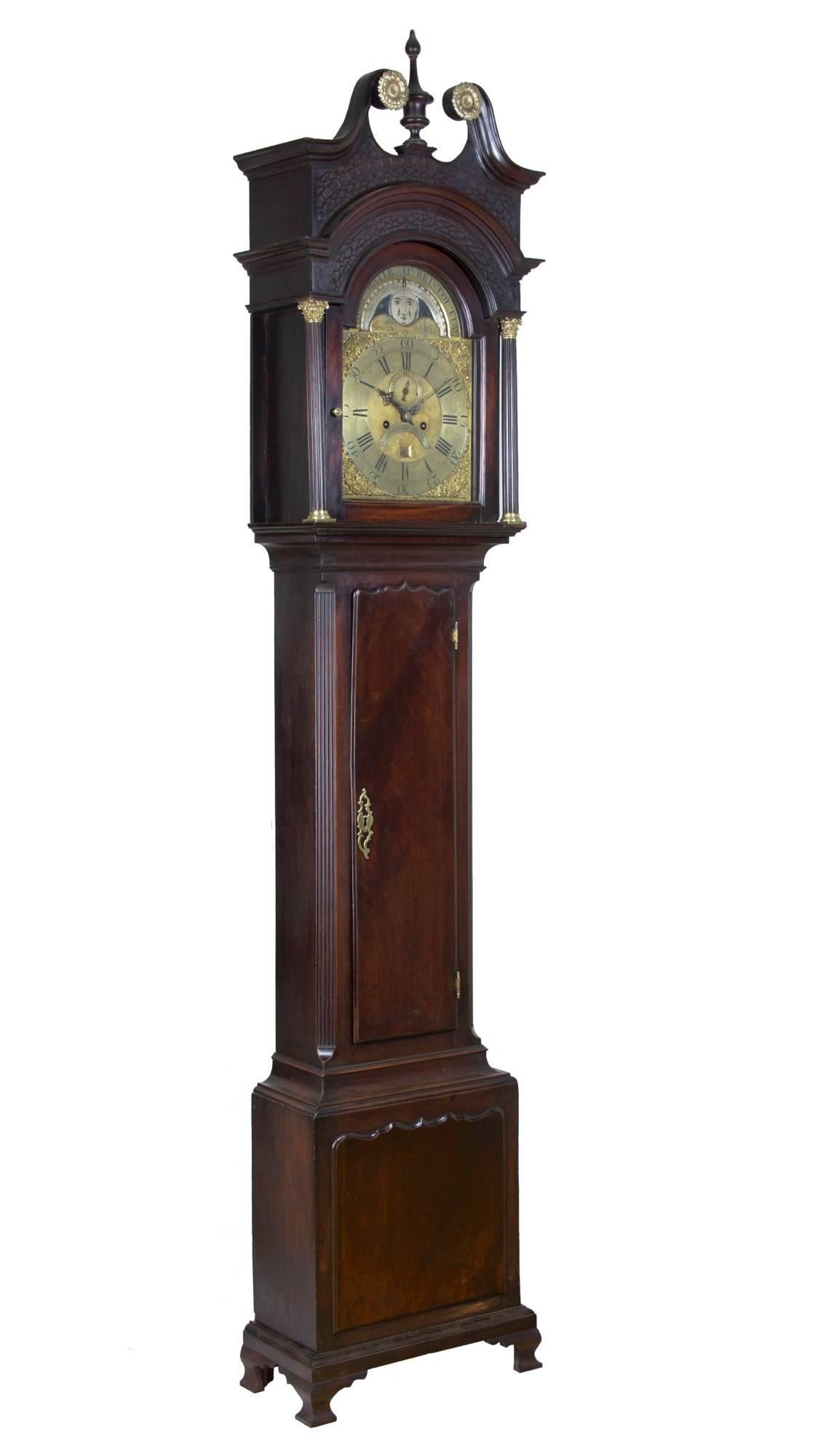 This clock is composed of heavy, dense, striped Cuban mahogany. Note the wood quality of the large midsection door and the base panel. Additionally, the double stepped hood hearkens to a slightly earlier time-frame and the blind fretwork is