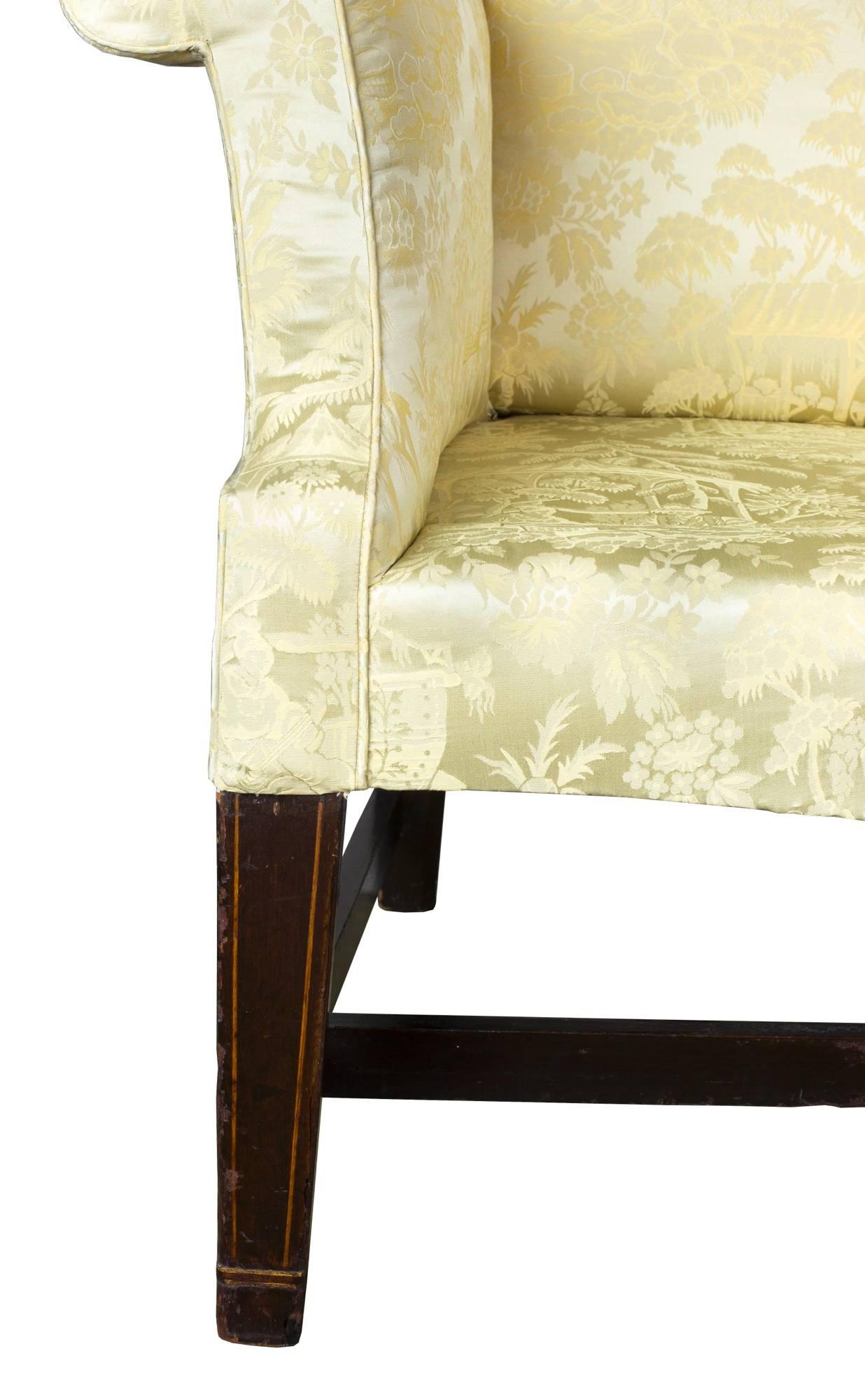 This is a fine, comfortable small-scale wing chair, with Classic Philadelphia wings and outward stretching arms, circa 1780. The seat is further bowed, relating to the curvature of the crest rail. The legs retain an old surface, with line inlay.