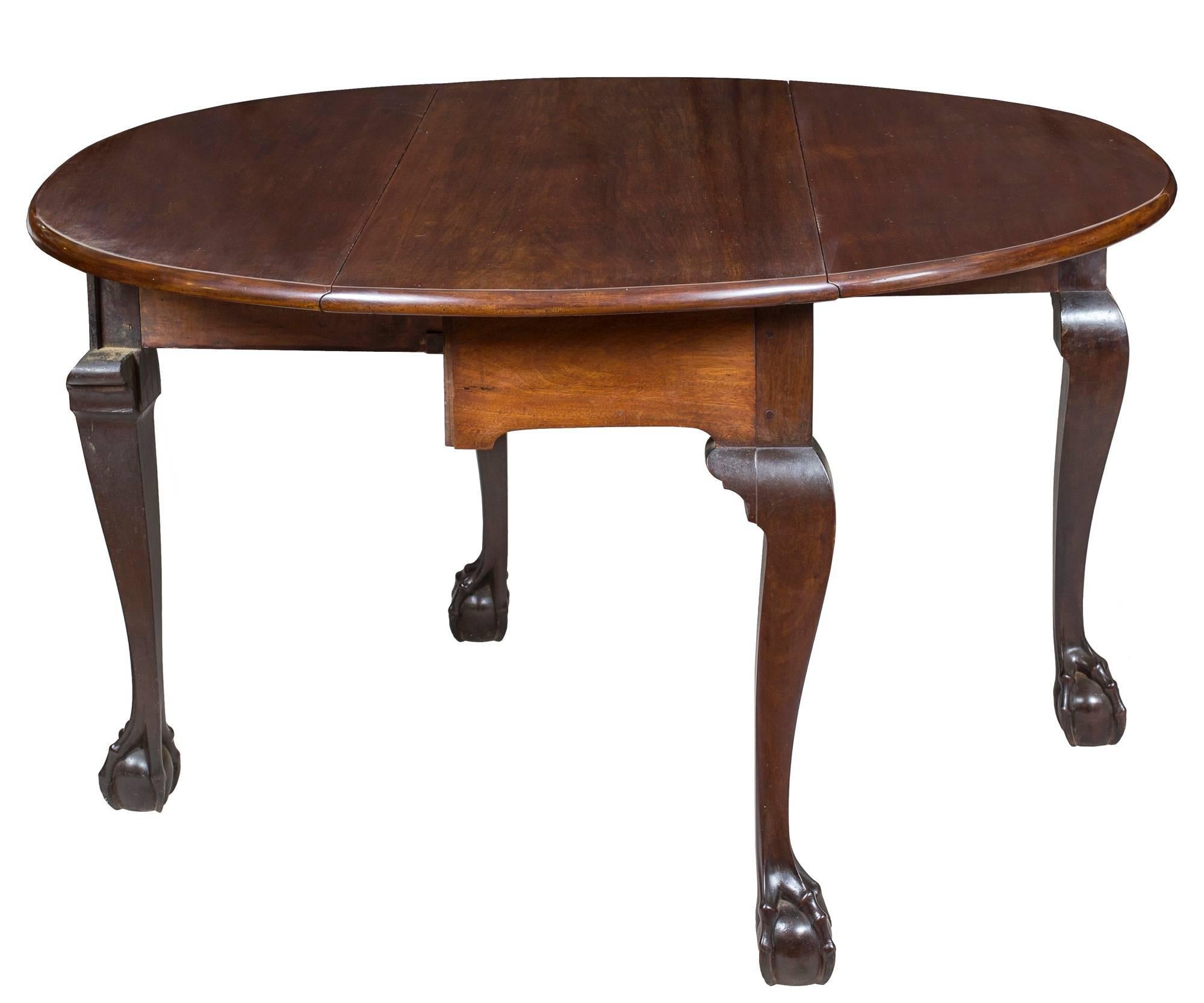 This table originally was the middle section of a large banquet table, of which the middle leaves were reshaped to make it a drop-leaf table of substantial size. Ordinarily we would not handle a reconfigured piece. However, the legs are absolute