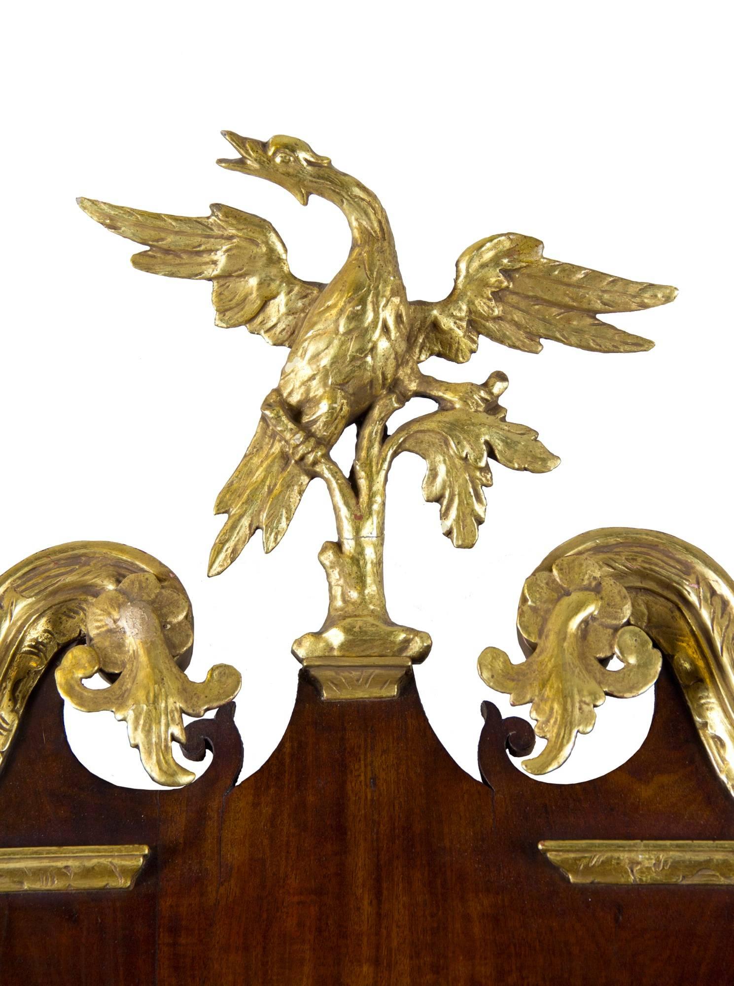 This mirror is in extremely fine condition, retaining all its original parts. The phoenix bird is beautifully carved and rarer than the eagle which is generally seen on this form. This example has all of the flourishes one expects of a high styled