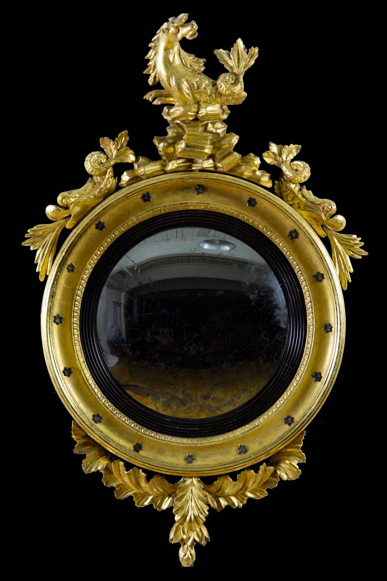 This is a moderately sized girandole mirror with notable classical embellishments. Whereas most girandoles usually have an eagle at the top, this one has the classical seahorse, above the traditional rookery, and flanked by spouting dolphins. This