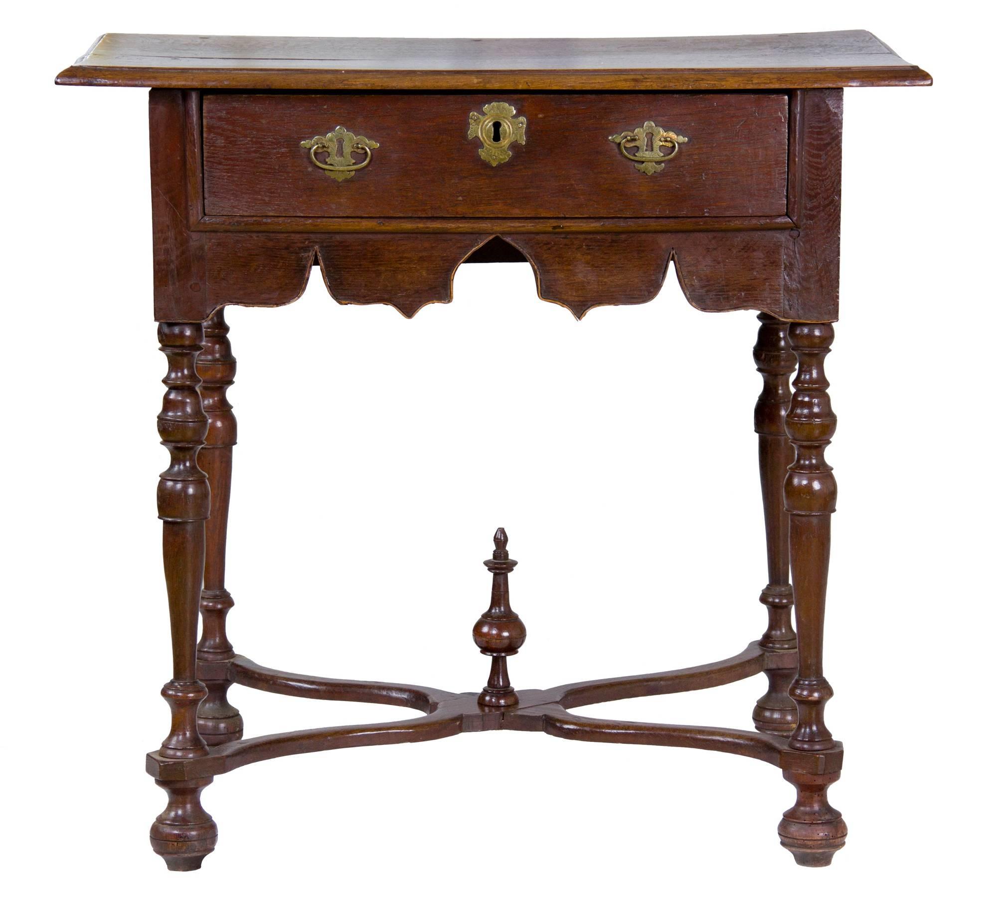 This is a beautifully executed table with a very gracious overhang and beautifully turned legs which retain their original bun feet, stretchers, and finial. In addition, the brasses are first, so this is quite a rare piece to find in this condition.