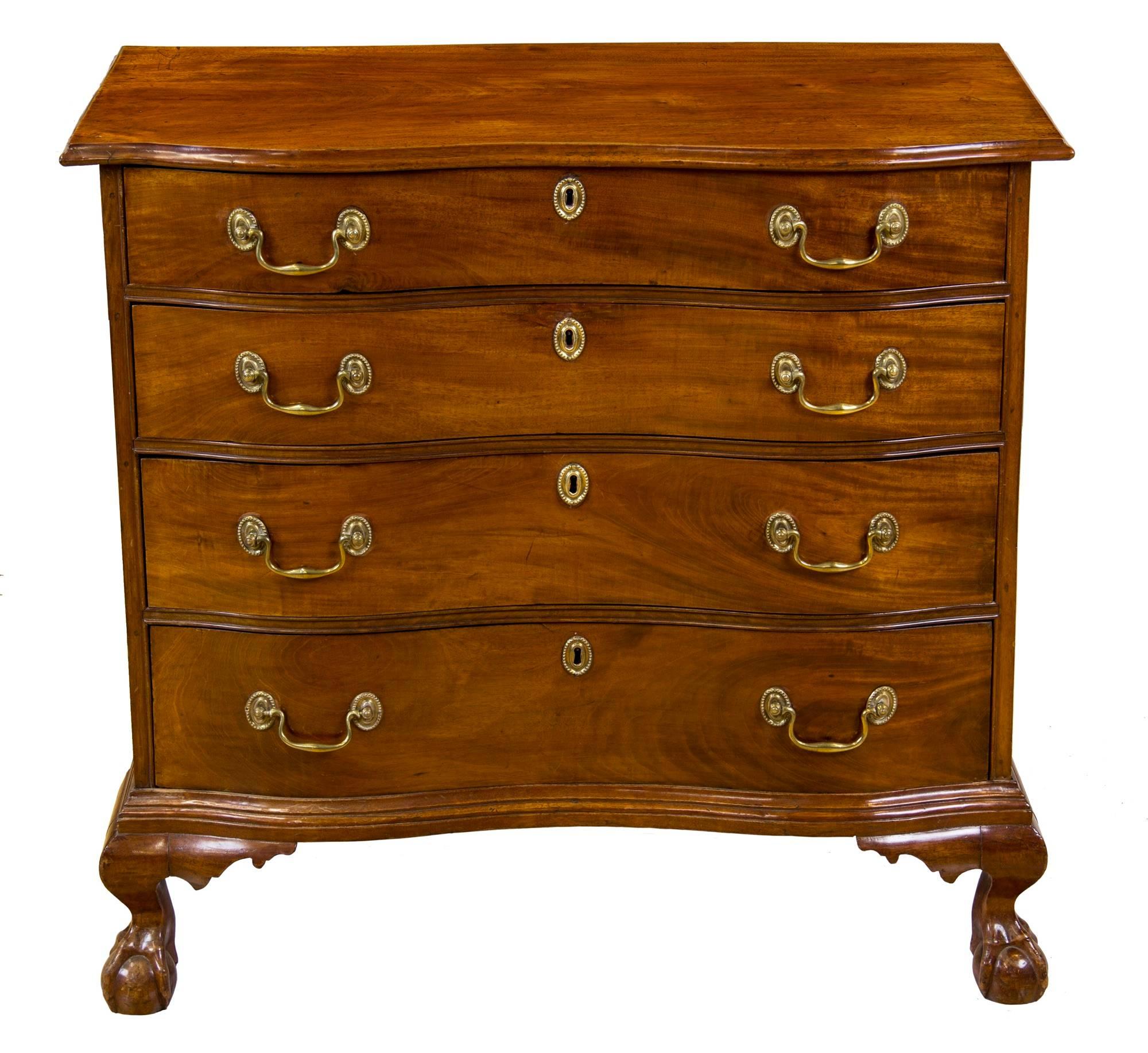 This chest is compact, 34 inches wide with a close conforming top and is elevated by four claw and ball feet, which are typical in style to those coming out of Boston at that time (see the scan for an oxbow desk from Newburyport, in New England