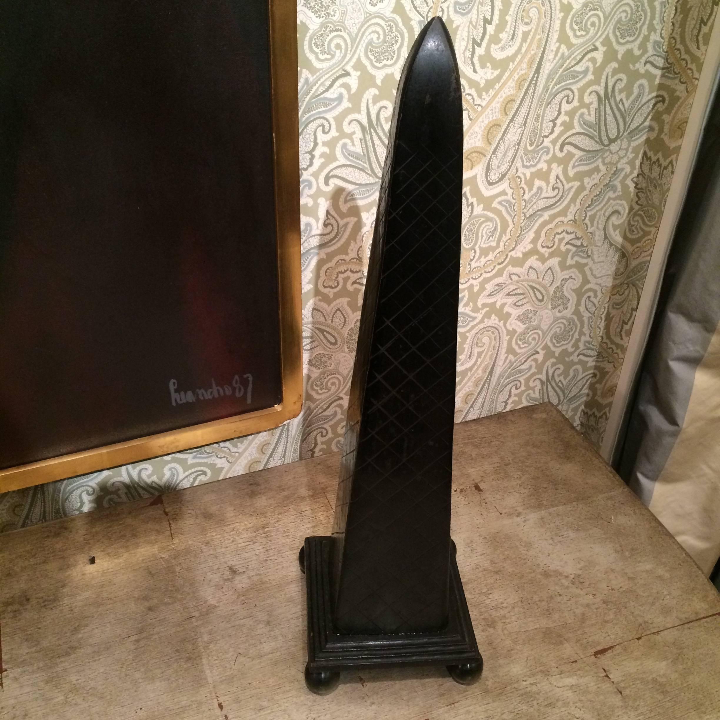 Very nice obelisk with cross hatch scored pattern on black bone-like material with black base and round feet.
