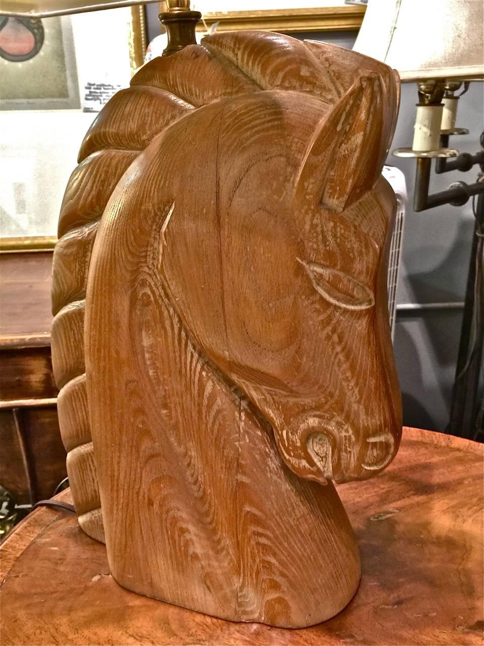 Stunning pair of iconic Billy Haines firmly attributed horse head lamps. The lamps retain their original cerused surface and are in excellent condition. They are newly rewired with new double socket electrical fittings.