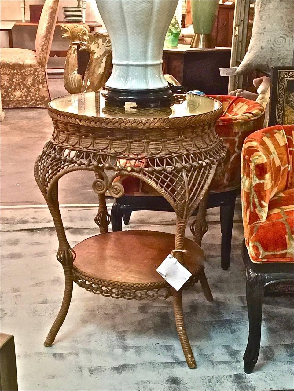 This is a great Heywood-Wakefield side table that dates to the early 20th century. The table is in excellent original condition and features a beautifully caned, lace design top, sexy curvy legs, wooden beading and lower shelf.