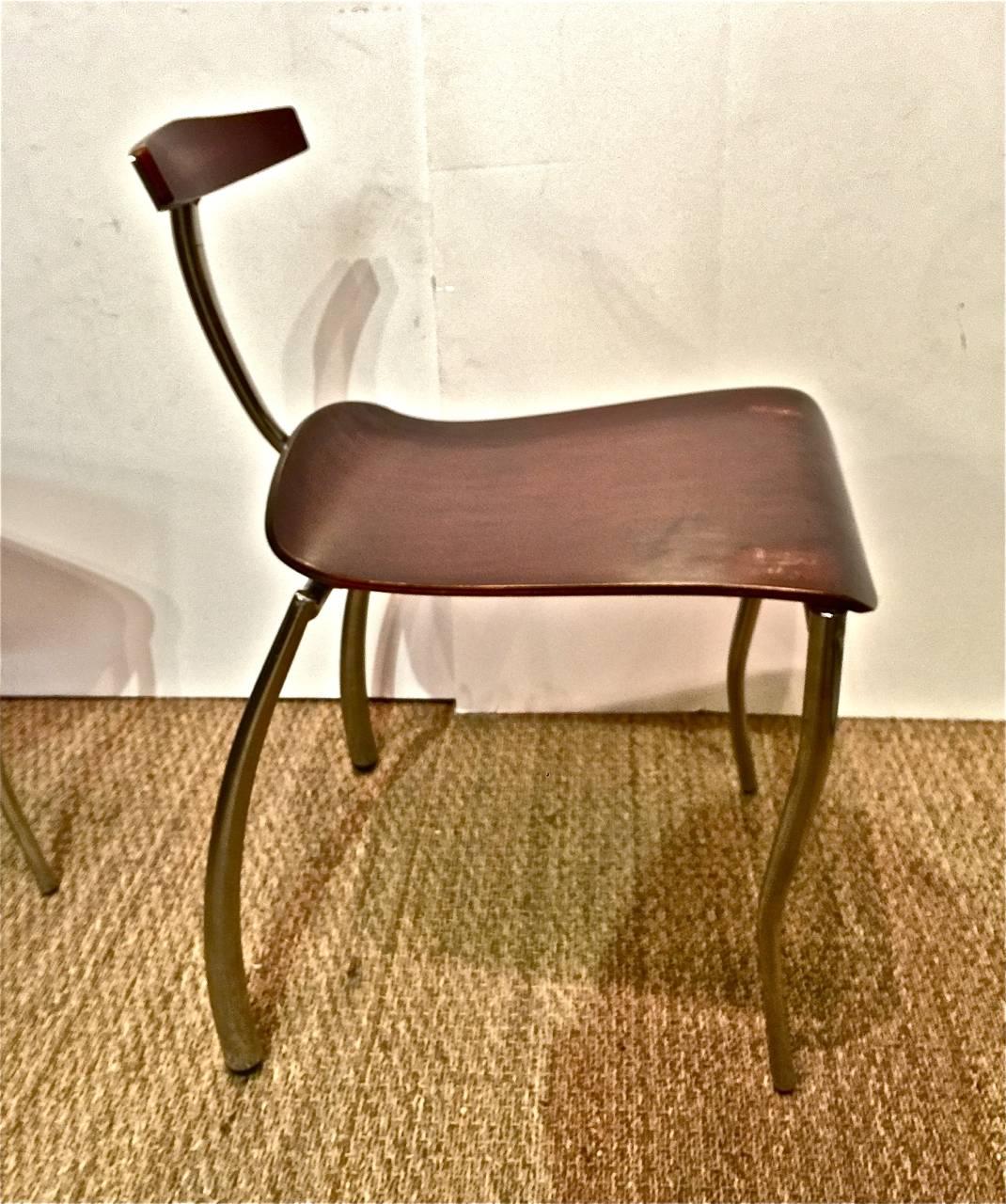 An unusual pair of Memphis attributed prototype side chairs that date to the 1980s. The chairs were crafted with forged and tubular steel and rosewood veneered plywood. Note the addition of the section of wood added as a support for the seat. Both