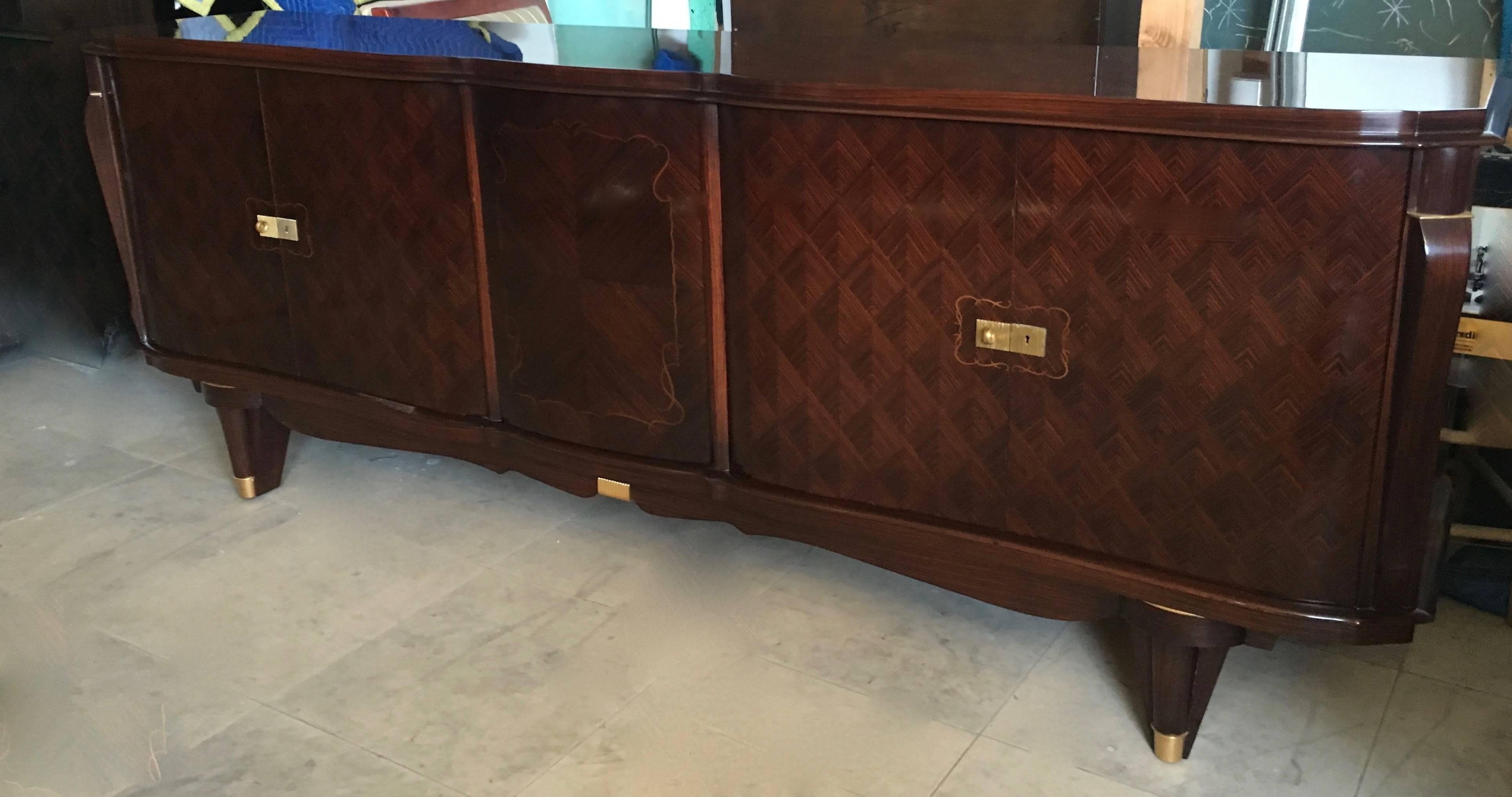 French deco buffet in Macassar ebony diamond inlay, circa 1940. Bronze detailing on legs and stand and lower middle - 5th door reveals six pristine red wool felt-lined drawers for your special linens, flatware, etc.

This piece is pristine and