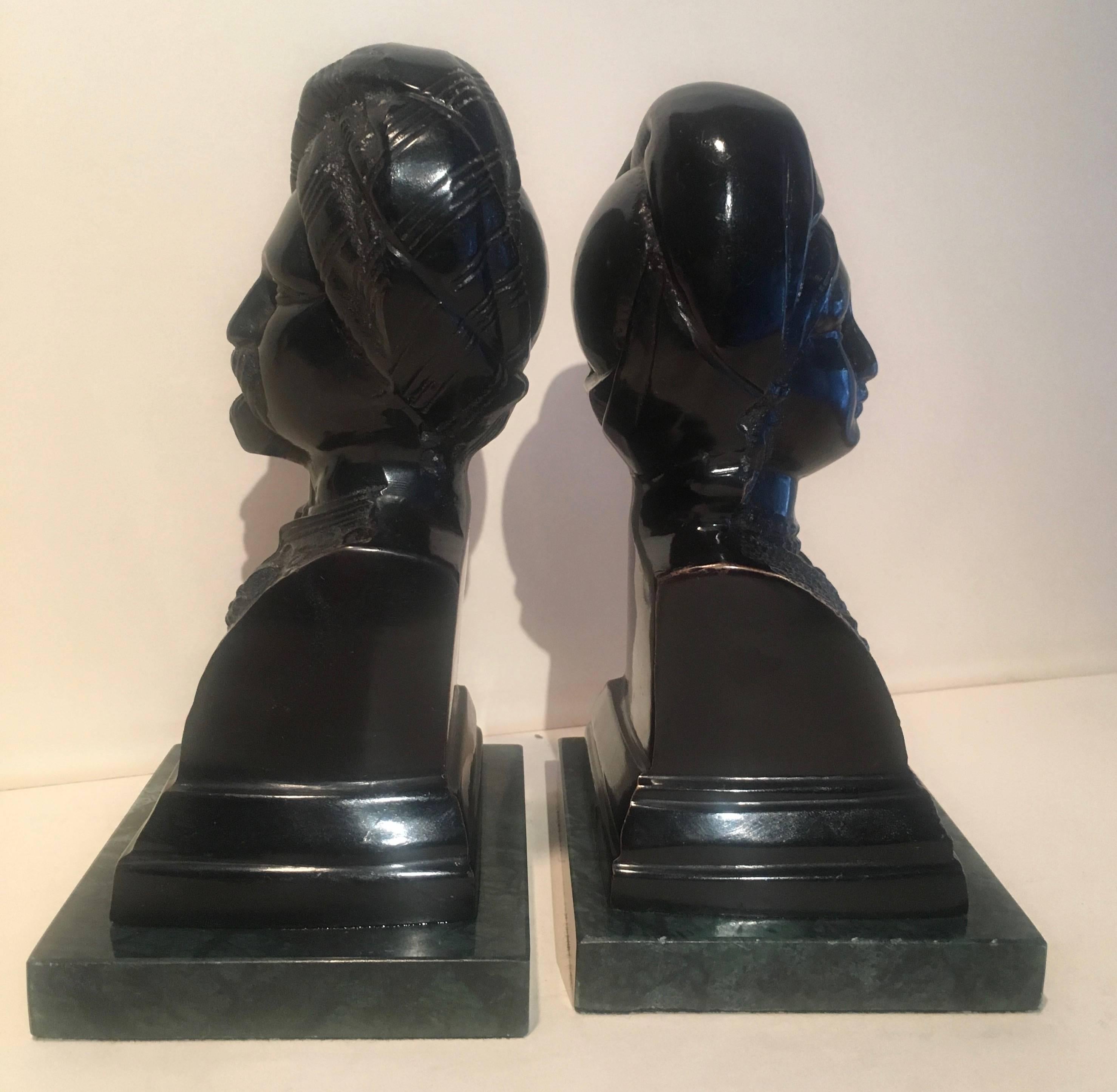 Lovely pair, Maharaja or Maharani bookends, lacquered black on plaster with Verde marble base.