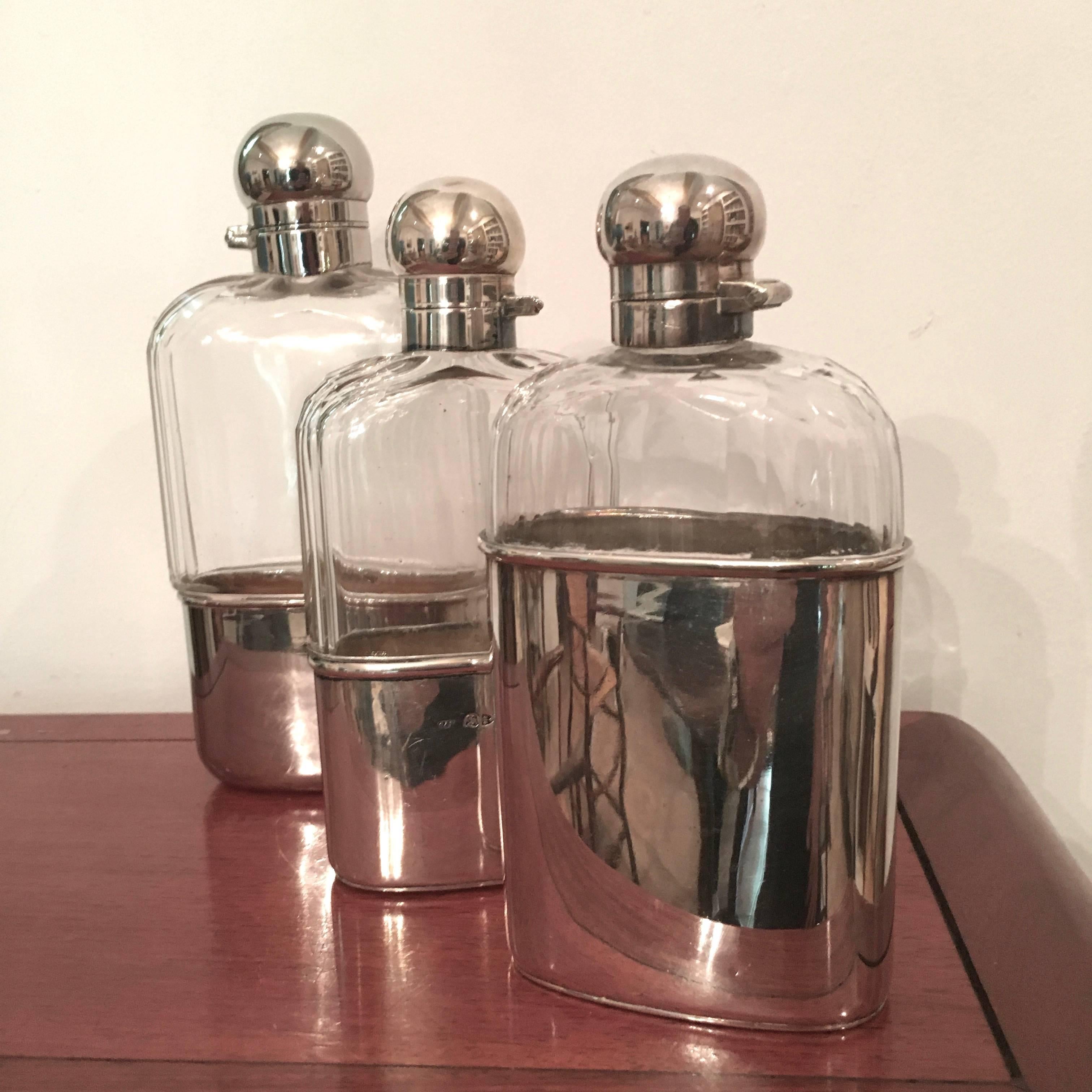 Three very handsome sterling and cut crystal flasks by Rowland's & Frazer, 146 Regent London.

The flasks are of good weight (and anxious to be a few fluid ounces heavier with your favorite spirits). Secure closures and elegant thoughtful design.