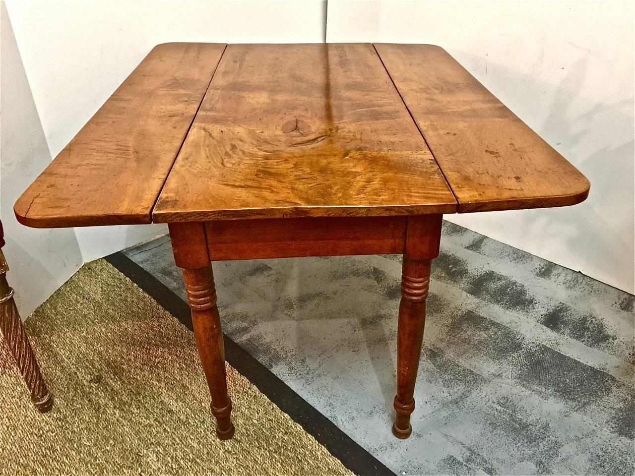 This is a unique example of an American late Federal or early Sheraton child's drop-leaf table, circa 1820-1830, in beautifully figured maple. The legs are beautifully turned and the drop side display shaped edges.

The table retains an old, if