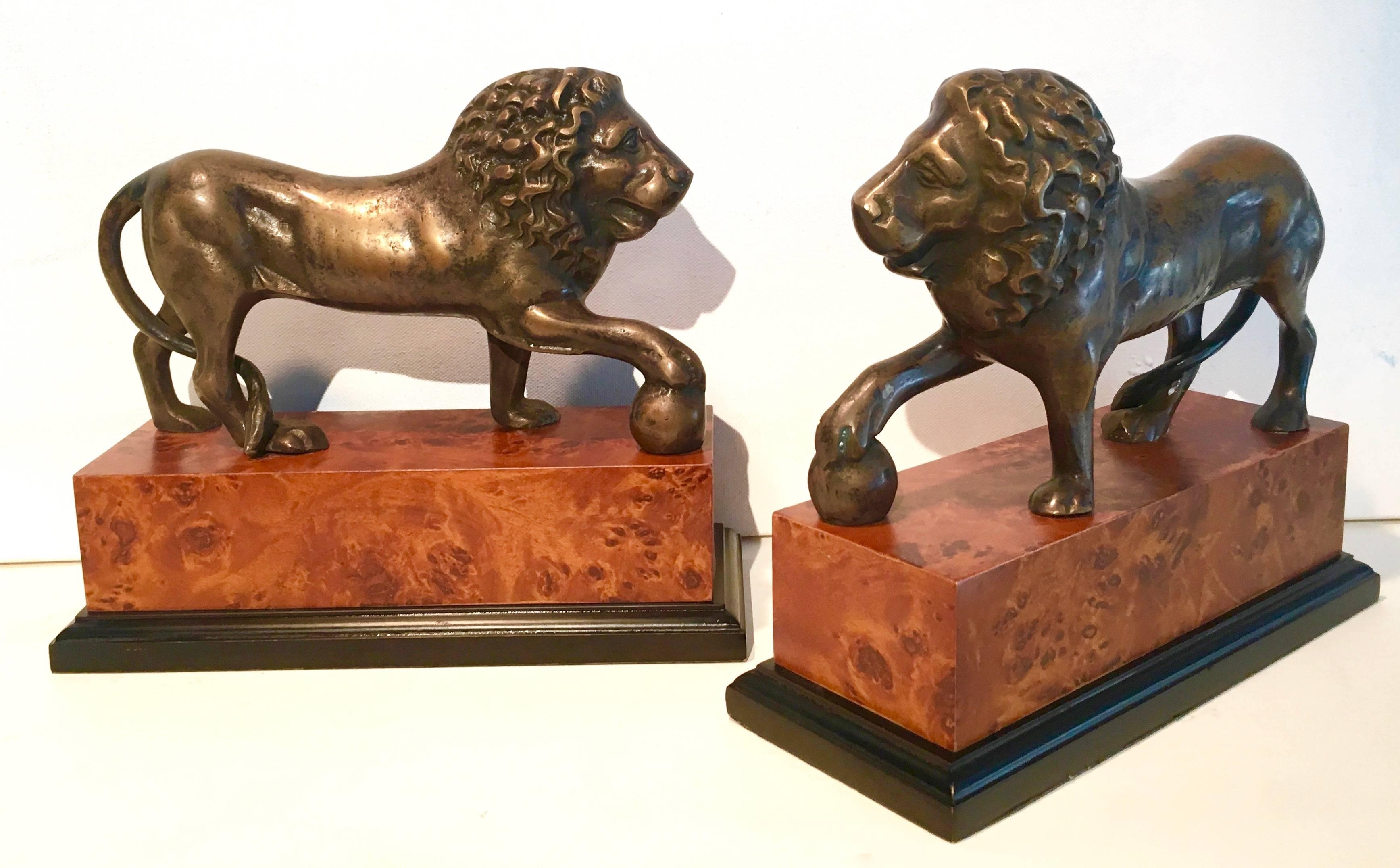 Pair of brass lions on a burl wooden base. The pair are quite large and will make an impression on any shelf! The pair will hold larger books great for the den, library or child's room!