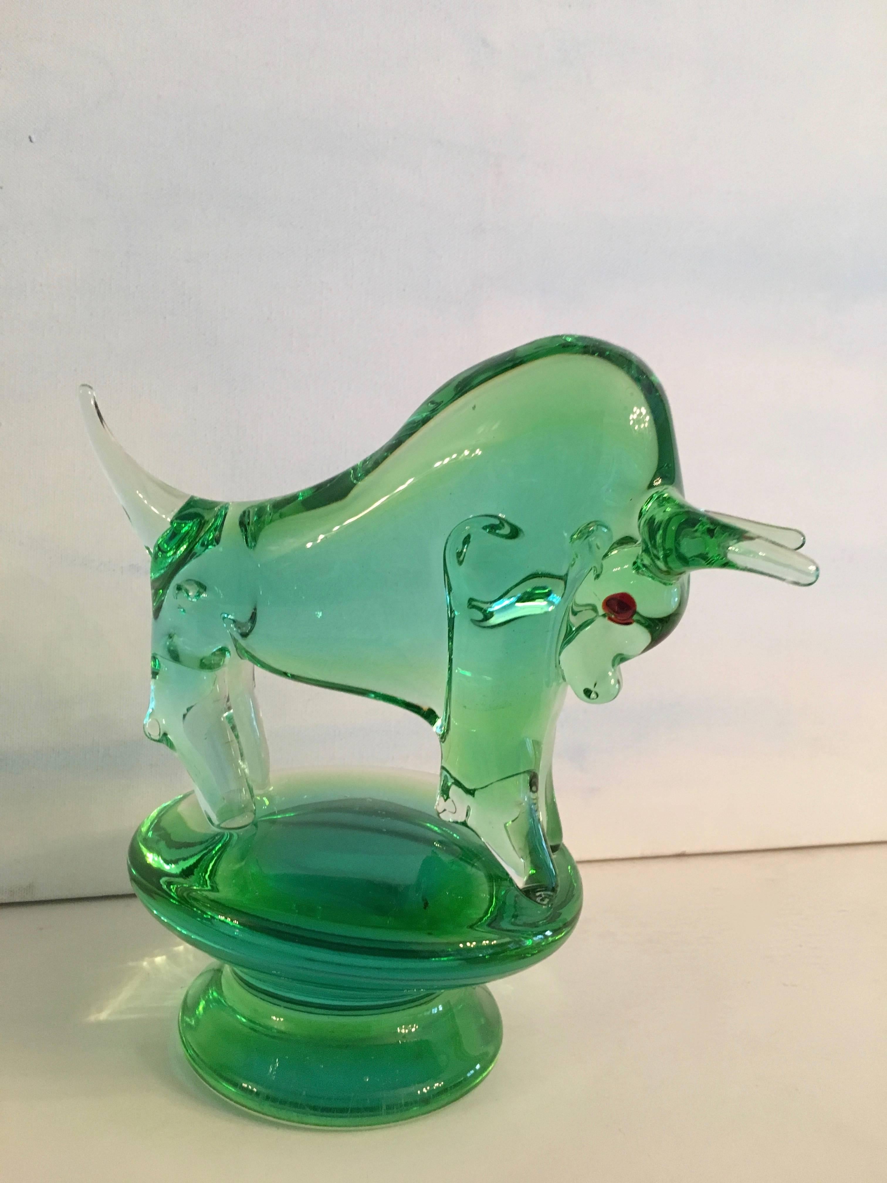 An exceptional and unique Italian Murano bull of green glass, red glass eyes detail the face, this bull is substantial and situated on a large block glass stand, wonderful for any room on any shelf, guaranteed to make a statement and be a