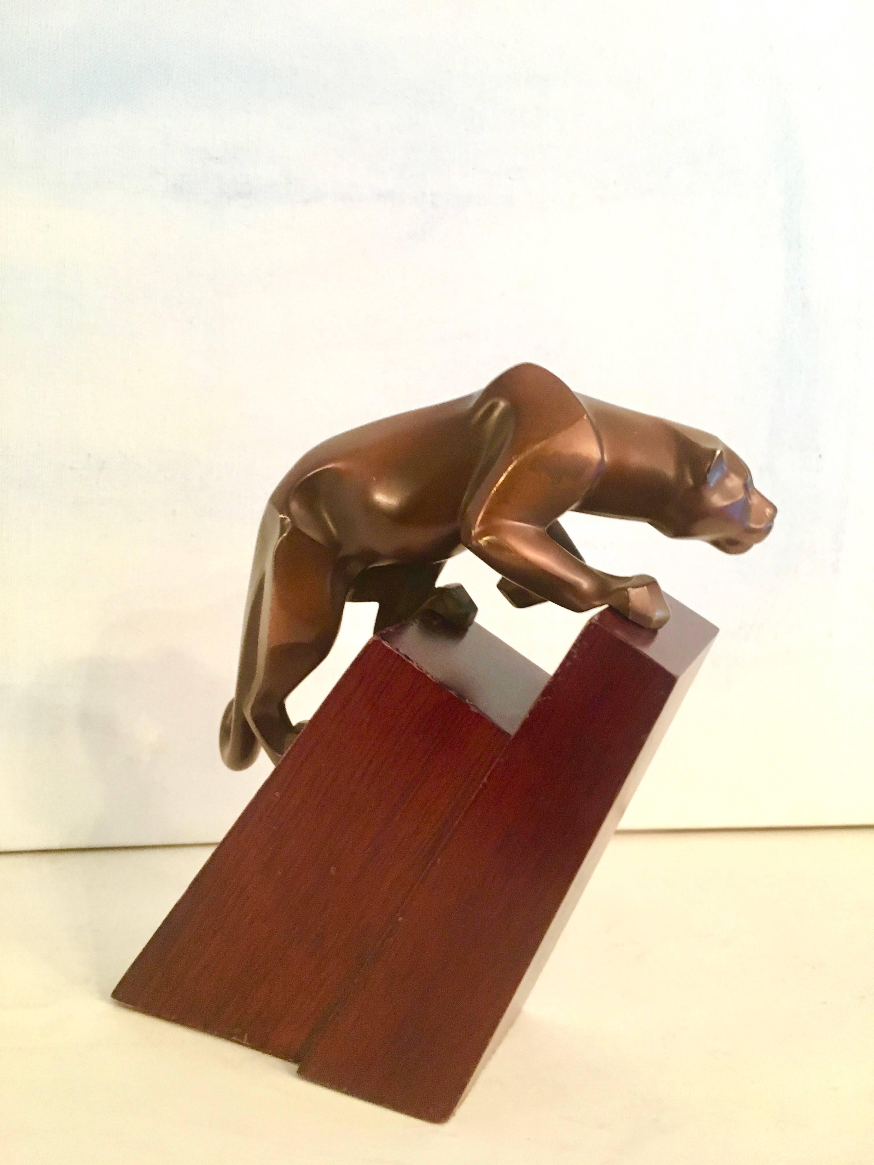Bronze Jaguar climbing - a sculptural piece that also can second as a bookend. Two pieces, the jaguar is of substantial weight.
 
