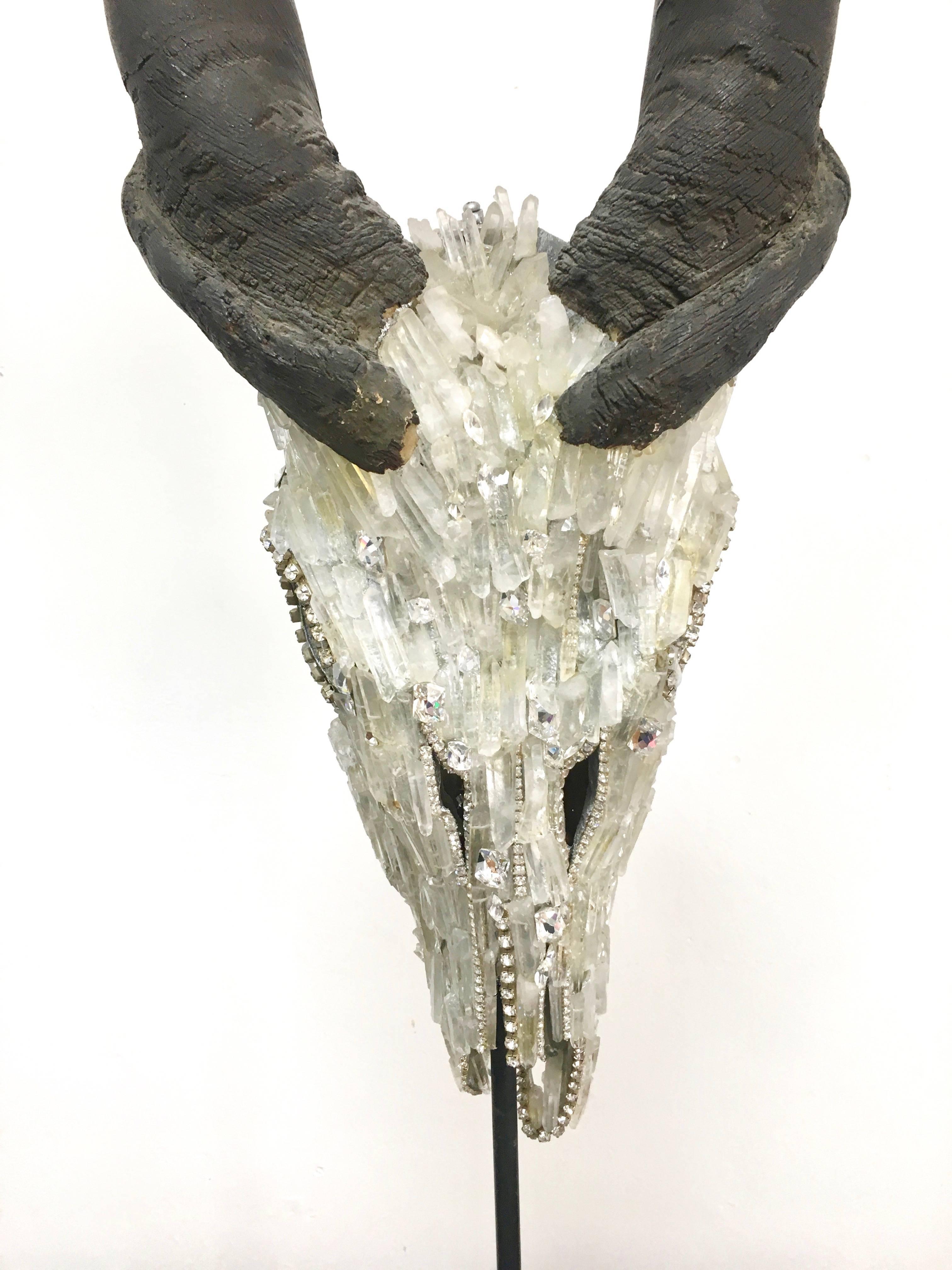 A very large Kudu skull with head encrusted in rock crystal points and Swarovski crystals, hand done work on a gallery stand.  In the Manner of Alexander McQueen.. 

The brilliance of the crystals is dazzling in person, especially when placed under