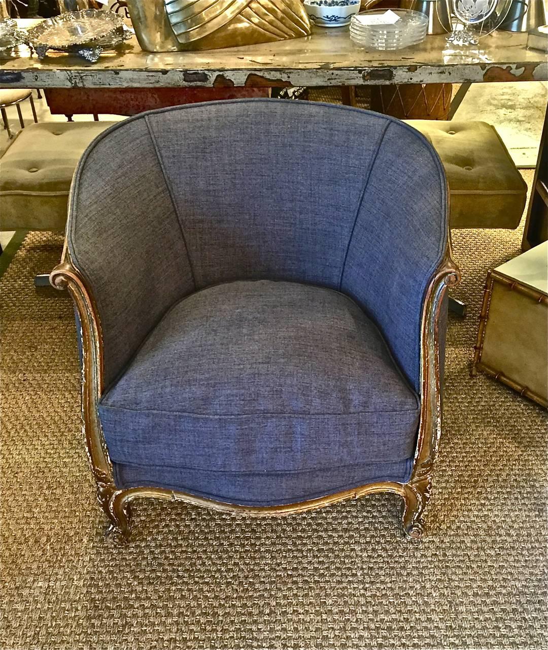 Pair of period French deco barrel-back bergeres or club chairs.
These deco chairs are in the Louis XV taste and feature a carved walnut frame that surrounds the back of the chairs. The Louis XV style of the chairs, together with the chippy/worm