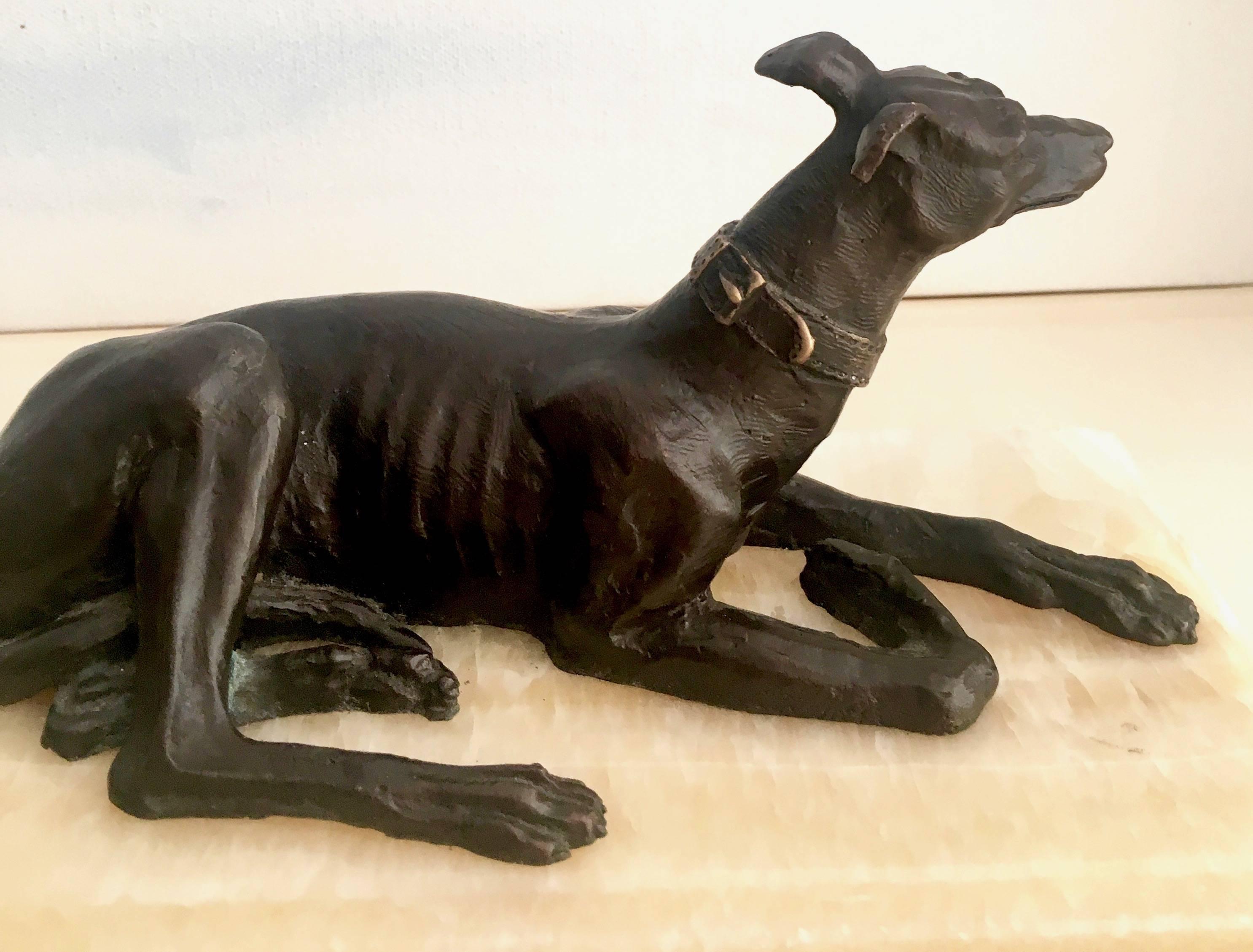Exquisitely detailed bronze sculpture of a lounging Doberman, great for use as a paper weight or decorative item on a shelf or table.