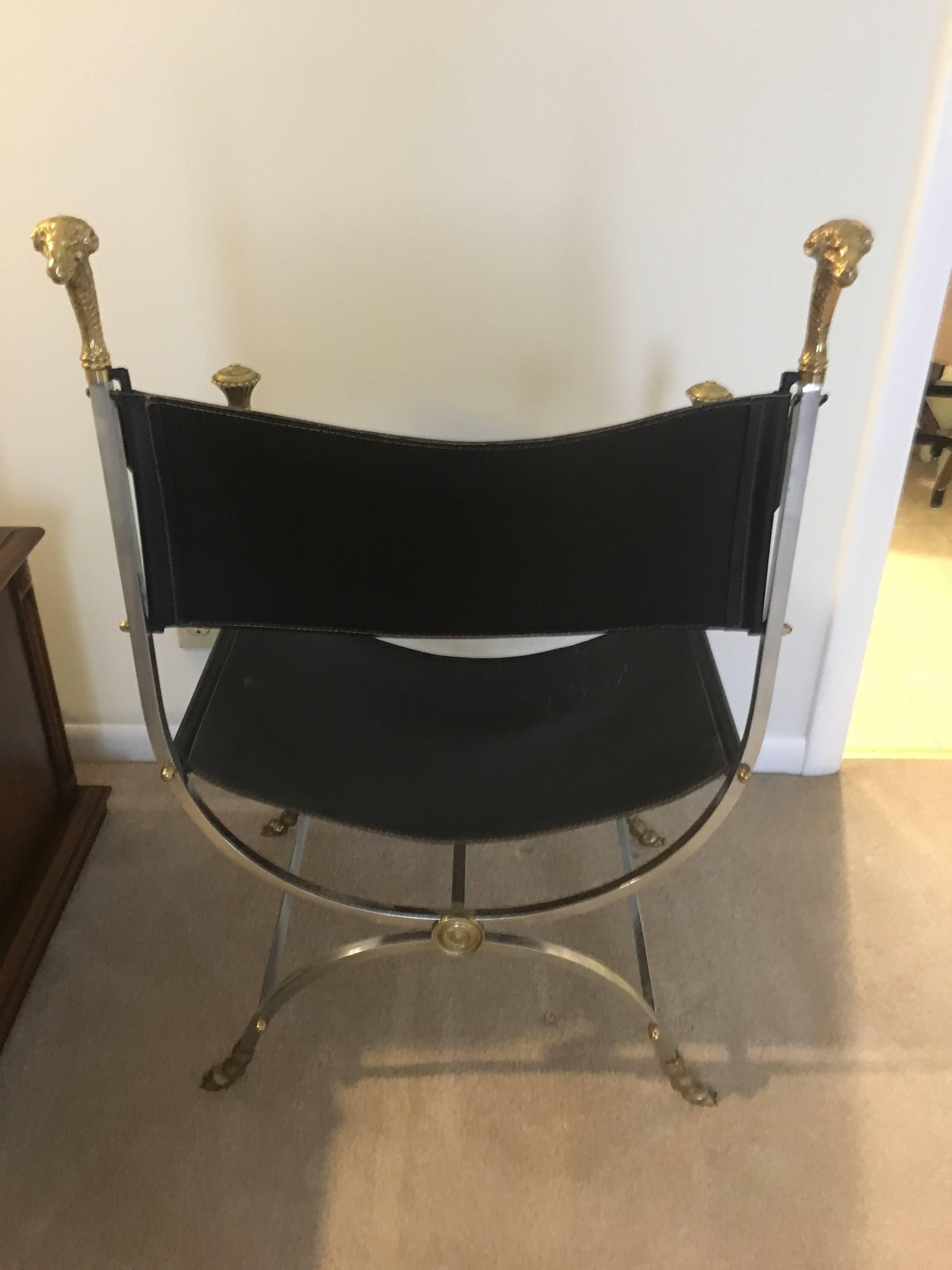 Beautiful Maison Jansen brass, polished steel and leather Savonarola chair. A fine example of Maison Jansen's detailing, from brass hoof feet to Medallions and finials on the arm and back. The rams are magnificent.

Introduced in the 1970s the chair