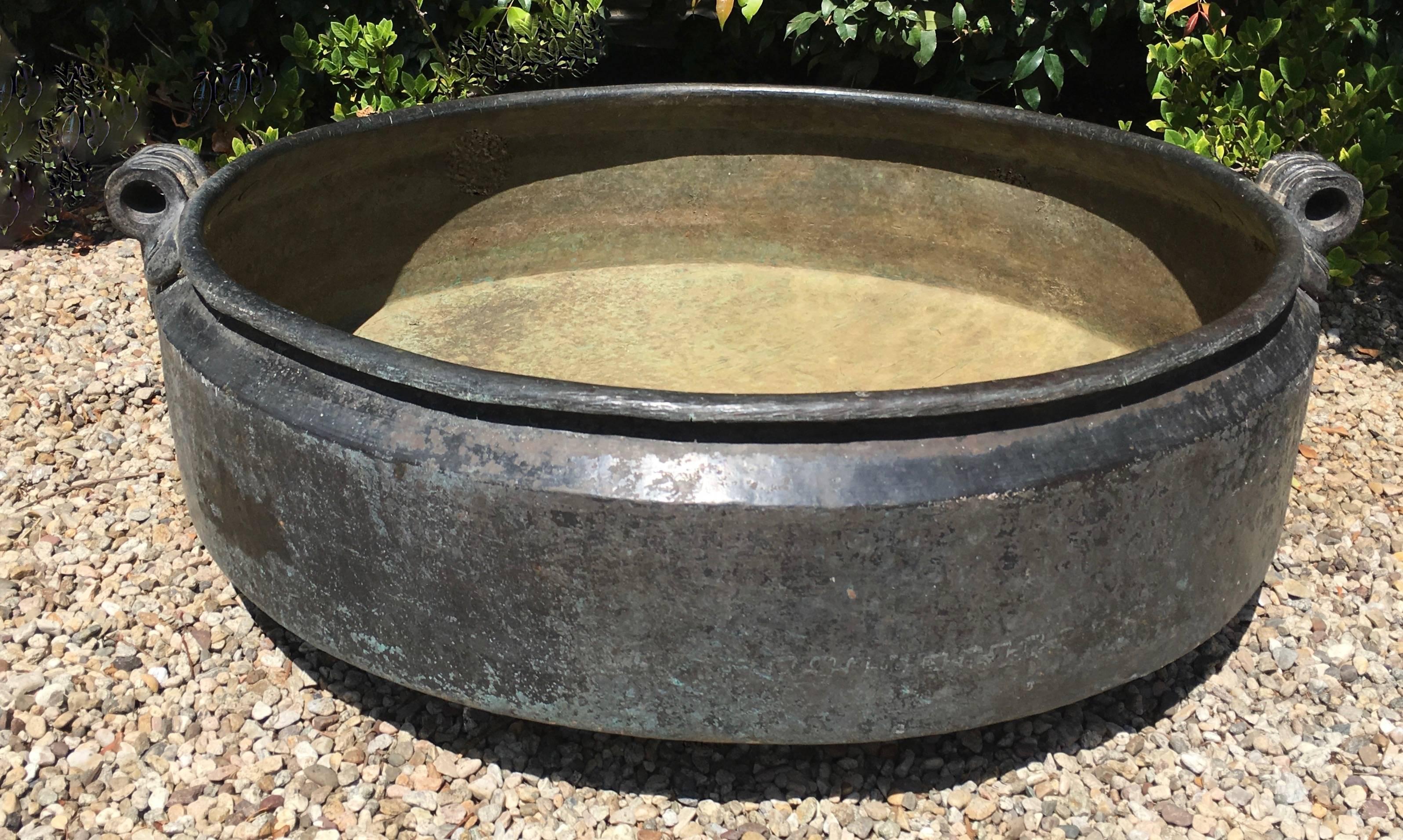 19th century Indian bronze urli bowl planter once used for cooking, the heavy bronze urli makes a great piece for plantings, a water feature, or perhaps to store firewood or blankets. 

The piece has a very good weight and is a compliment to any