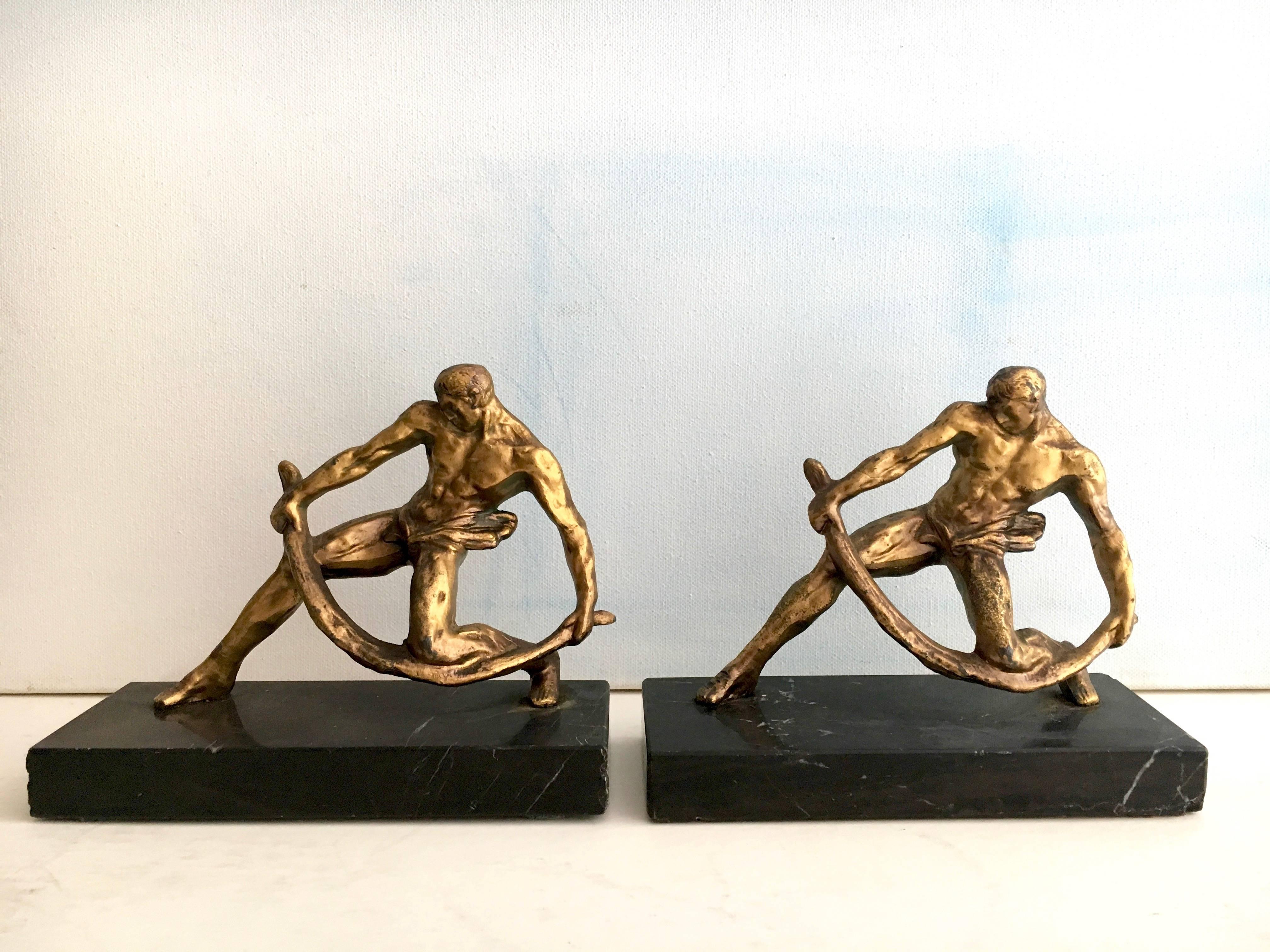 Who can't use two more muscle men around??

The pair are exceptional and will hold your finest periodicals! Stunning gilt figures, gracefully paired on marble stands. The marble does have a few nicks, but it's not the marble that will draw the