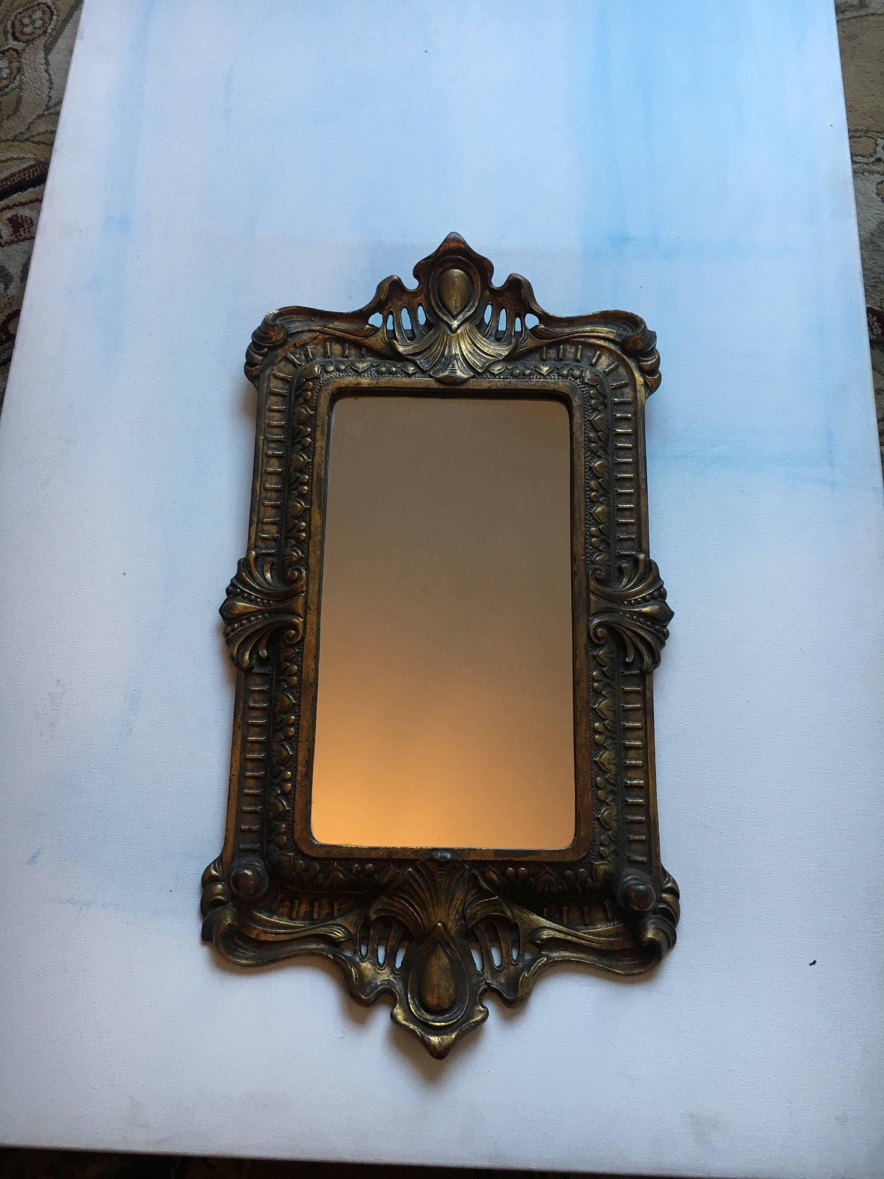Ornate bronze mirror tray, this piece can be hung for decorative purposes or used flat as a tray. Great patinated look and beautiful design.
The mirror has a crack that is undetectable, and hard to spot, see images.