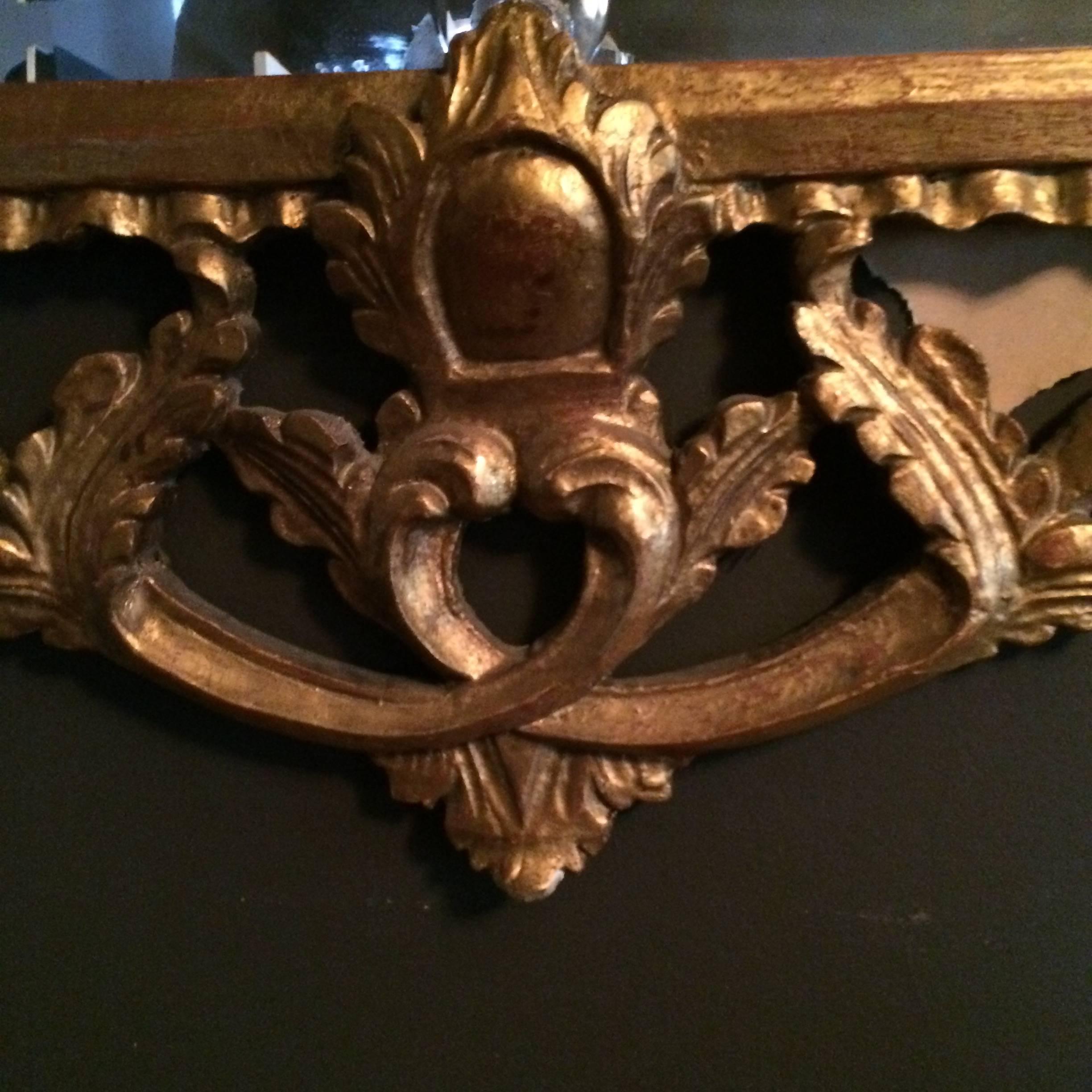 An impressive hand-carved mirror in giltwood great detailing and suitable for any room that needs a conversation piece.