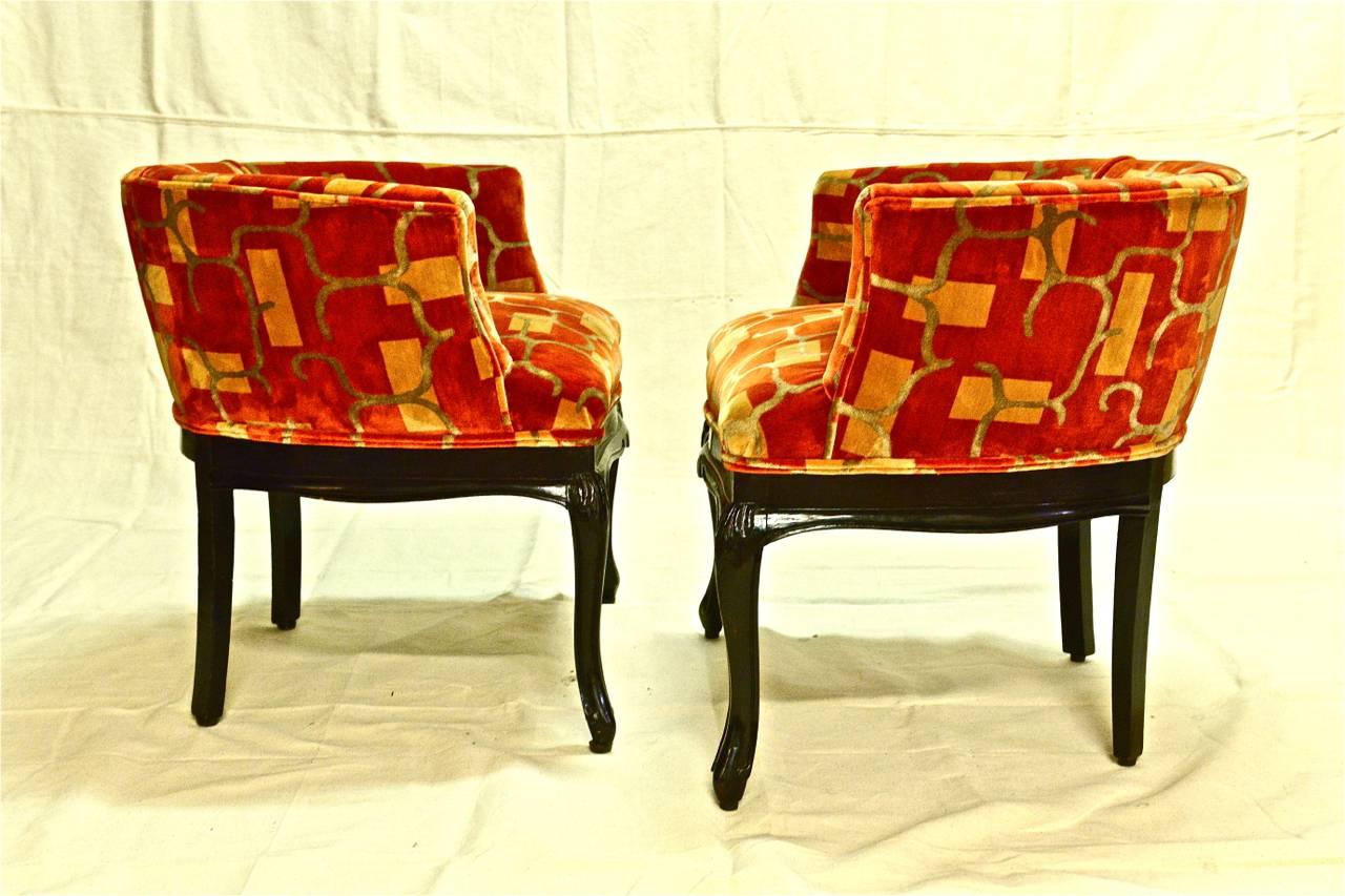 Pair of late French Art Deco Chauffeuses that have been newly upholstered in an abstract patterned silk velvet in the perfect shade of orange. These small bergères or boudoir chairs have been refinished in a high gloss black and are in excellent