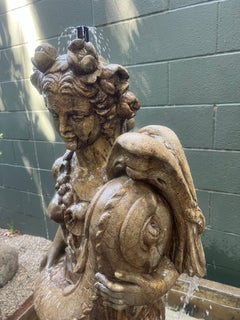 Fontaine européenne en pierre moulée représentant une jeune fille tenant un poisson koi