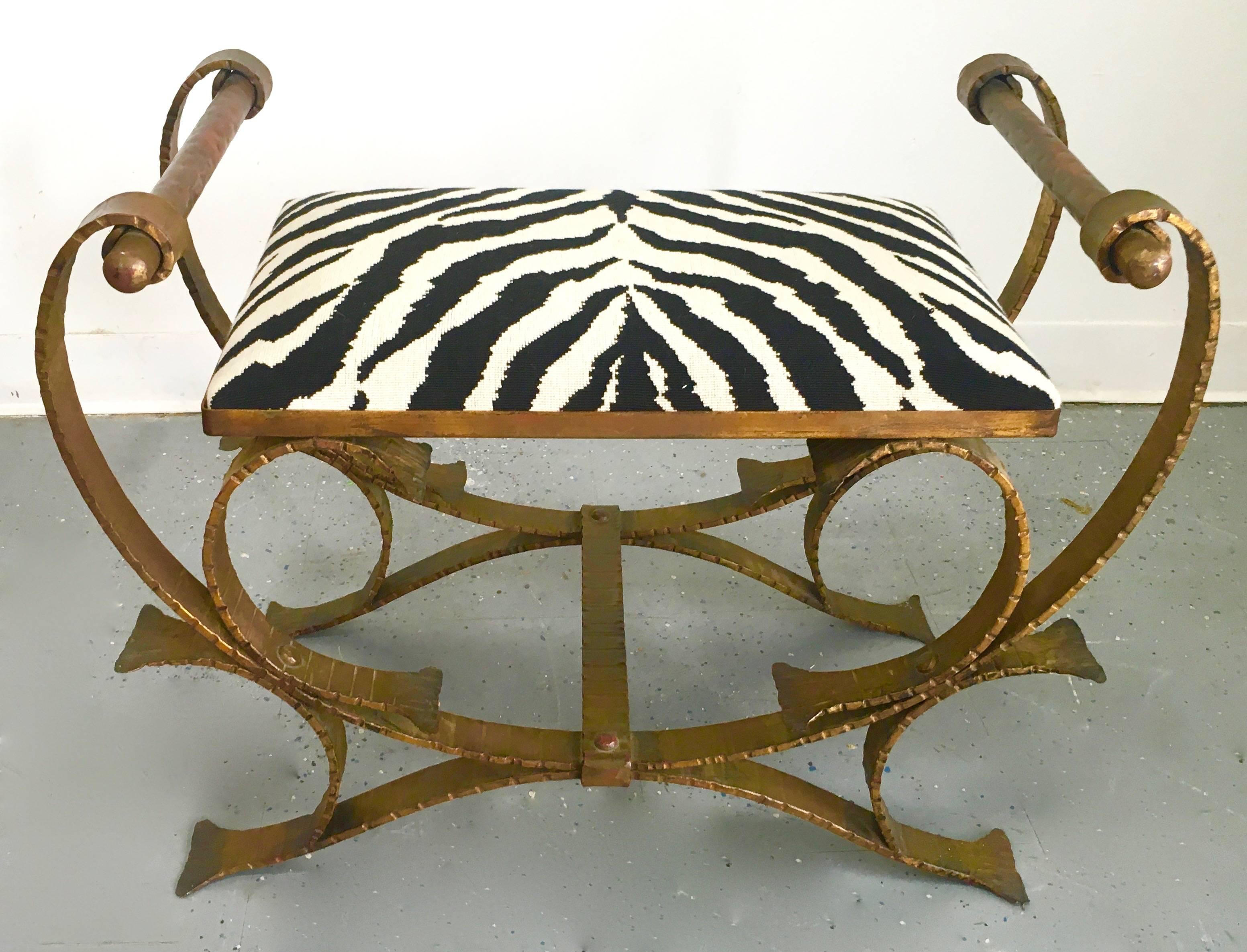 Early 20th century gilt classic wrought iron stool or bench upholstered in zebra print upholstery, the lines and attentive design definitely represent Hollywood in the early 1920s. Entire construction is hammered wrought iron, including the side