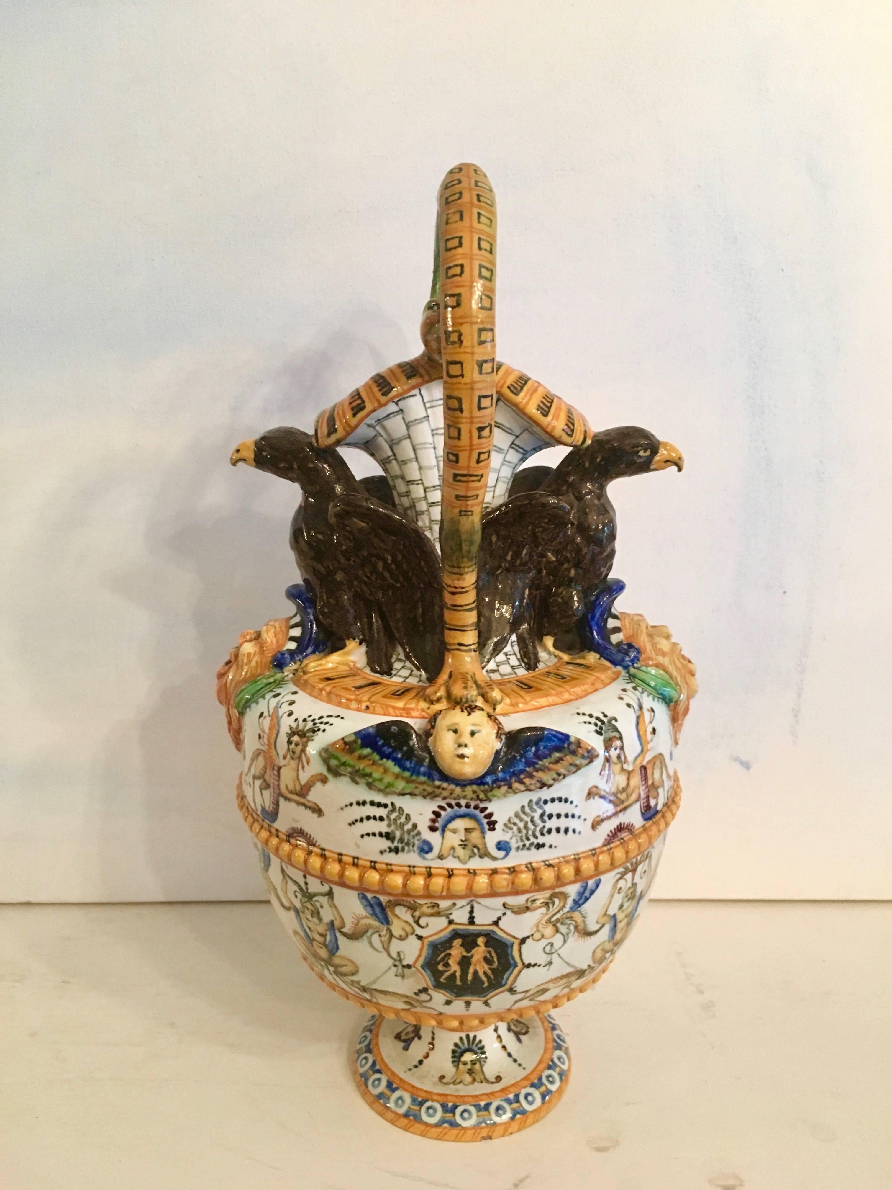 Stunning Majolica vase. Details on this piece are exceptional, from the Dual serpents forming the handle, with crows perched and beautifully carved faces set into the top, and mythological creatures of serpents, pan and phoenix to embellish.