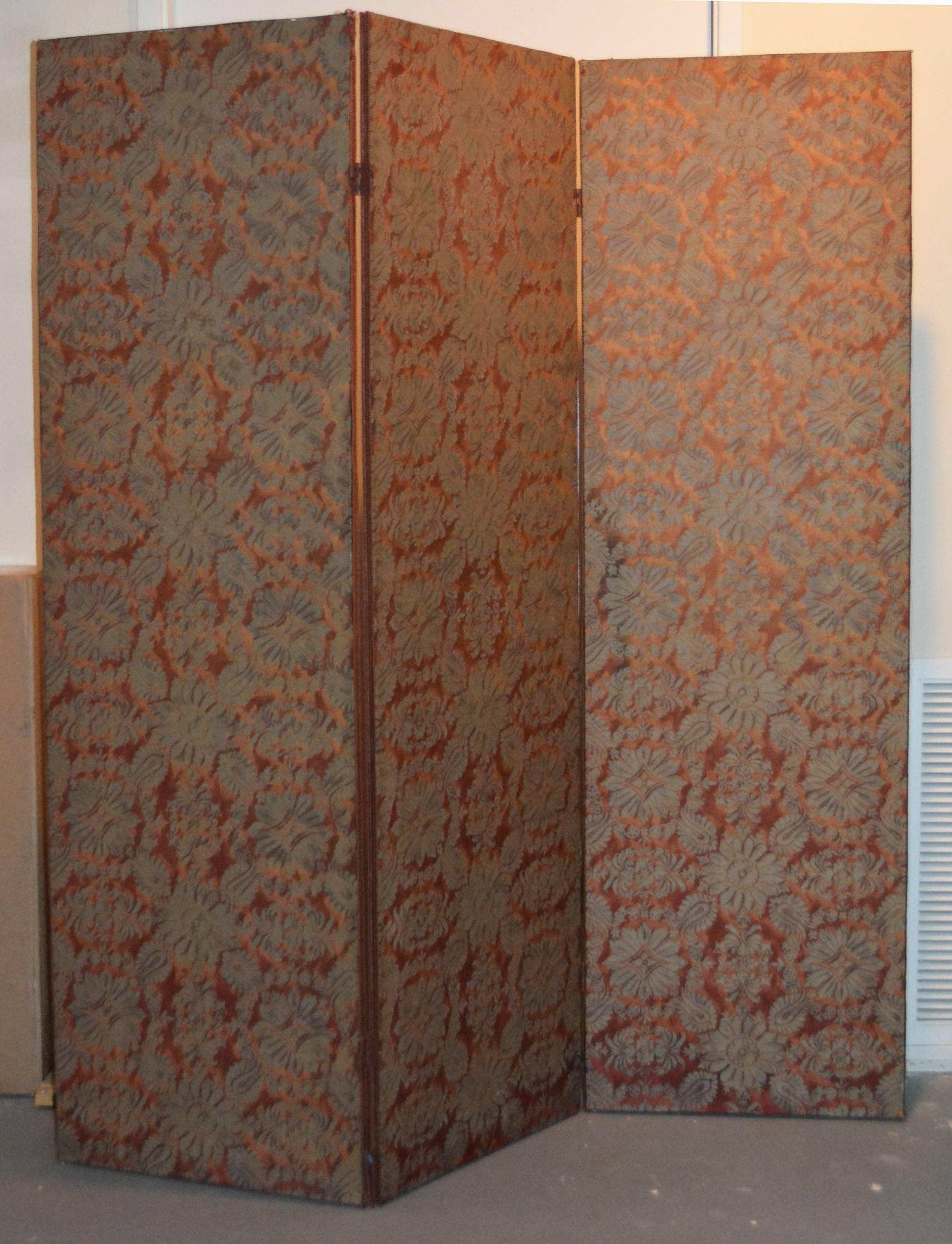 A lovely 1960s three panel screen covered on both sides with Fortuny "Impero" in copper and silvery gold. Excellent condition with matching gimp trim on edges.