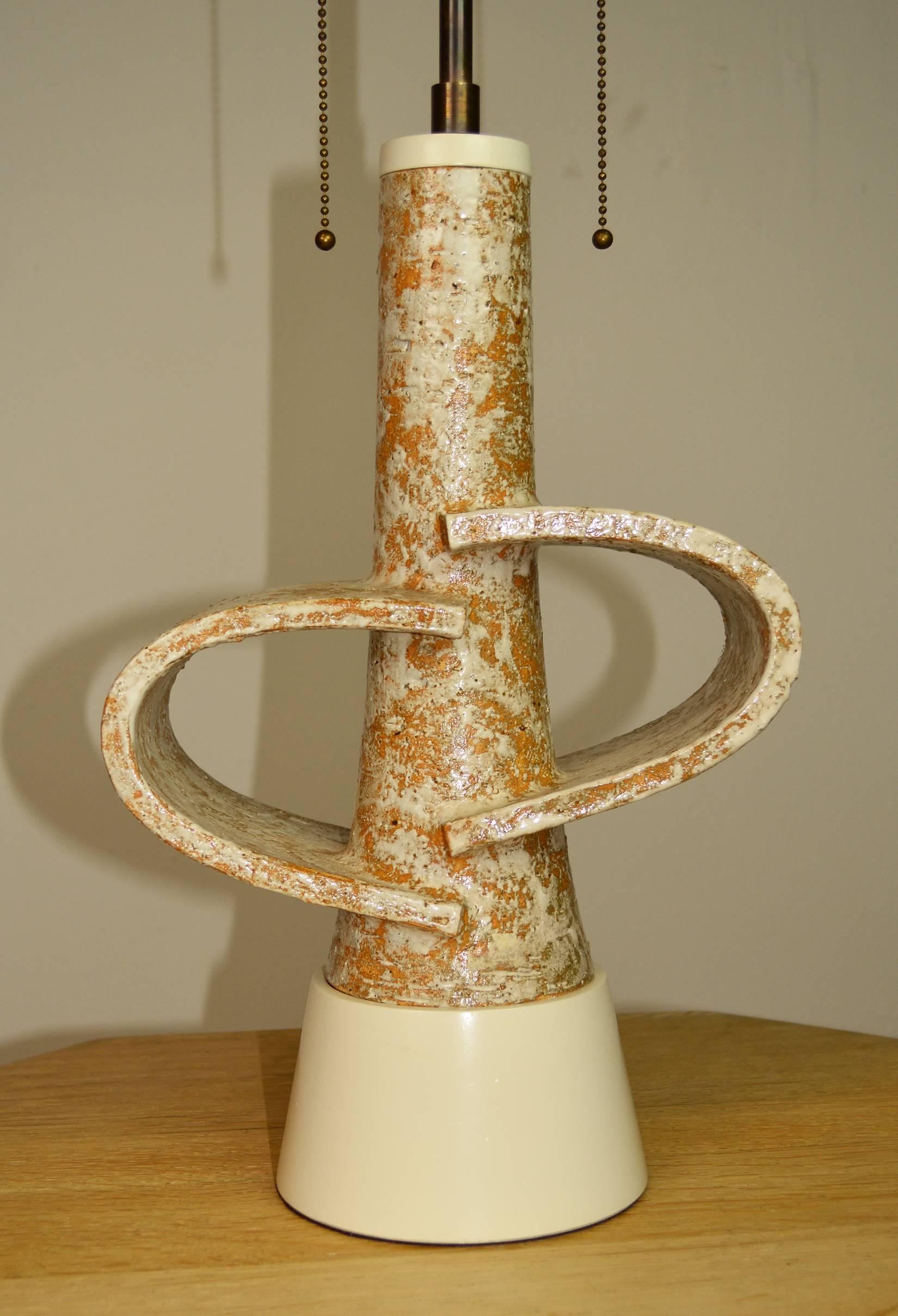 Sculptural lamp of rough glazed terracotta California Studio Pottery on a conforming painted wood base. New antique brass double cluster sockets with adjustable height shade holder and French braid silk cord. 23