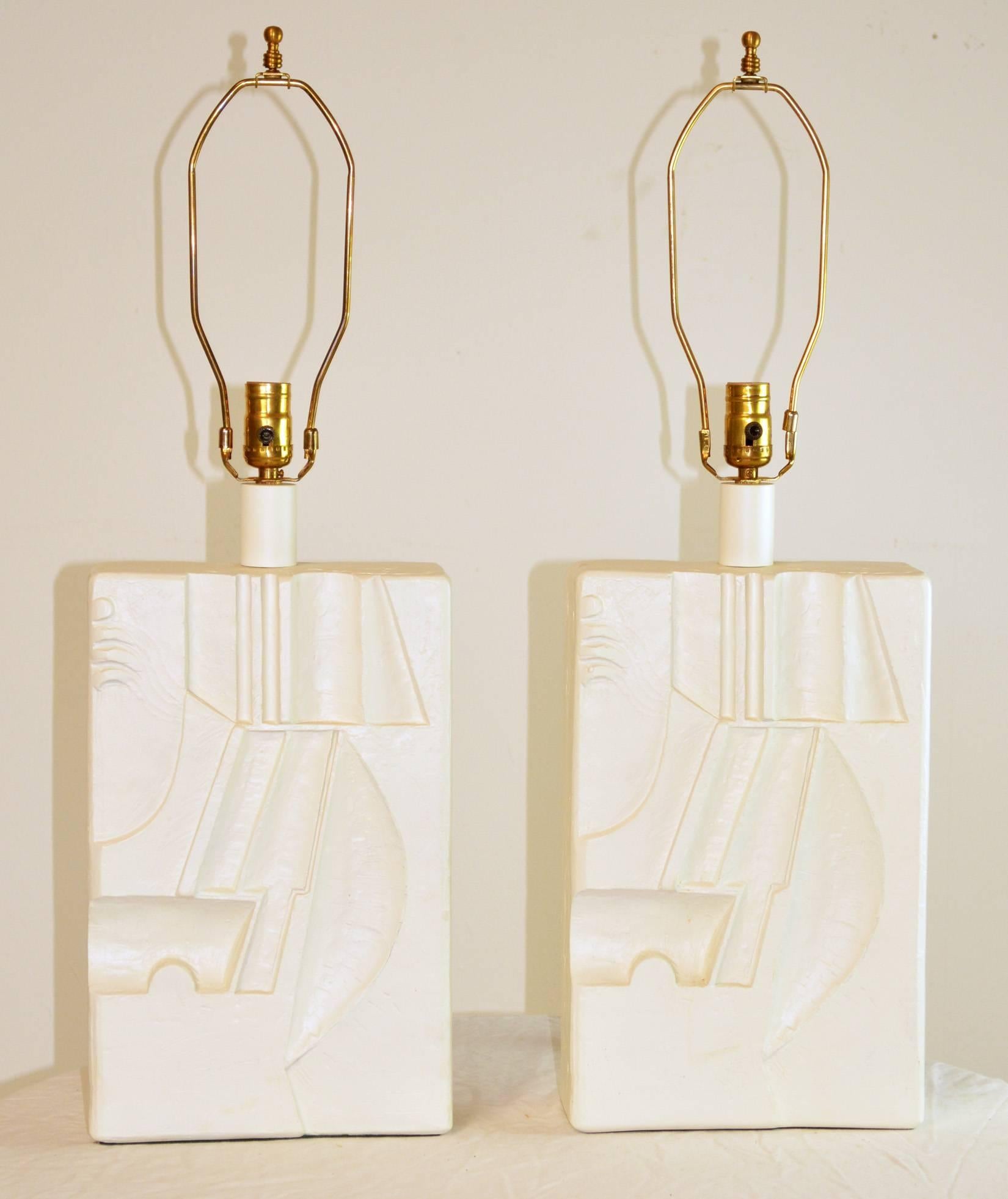 A pair of graphic lamps with incised sculpted decoration. Ceramic. 
Overall: 9.75" L x 3.75" W x 29" H. Height can be adjusted by adding a smaller or larger harp. Form: 9.75" L x 4" W x 21" H from base to top of socket.