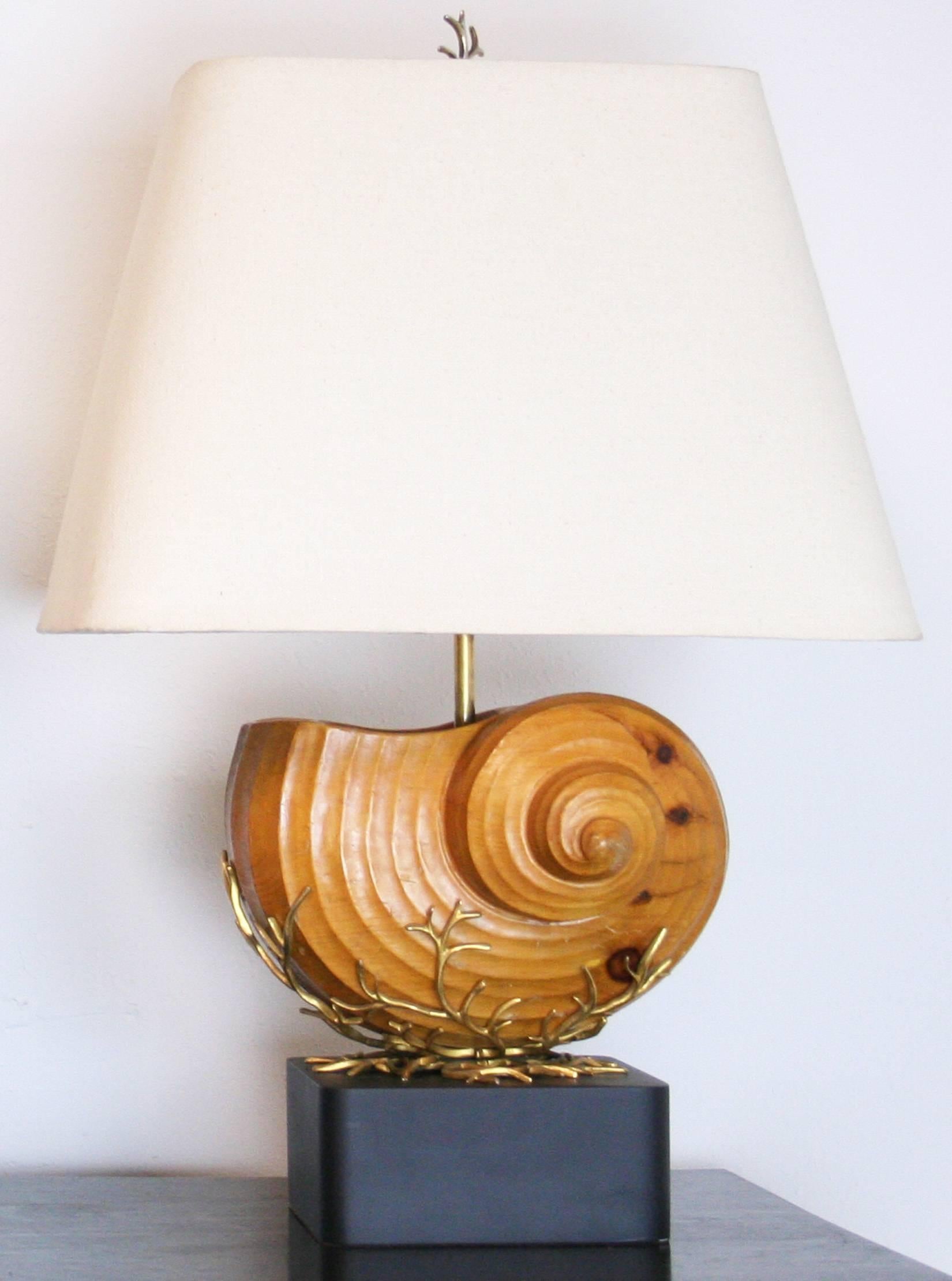 A pair of 1980s carved wood nautilus shells on gilt metal stands mounted as lamps on new painted wood bases with matching finials. Newly wired with double cluster sockets. Shades for display only. Mid-Century modern style.