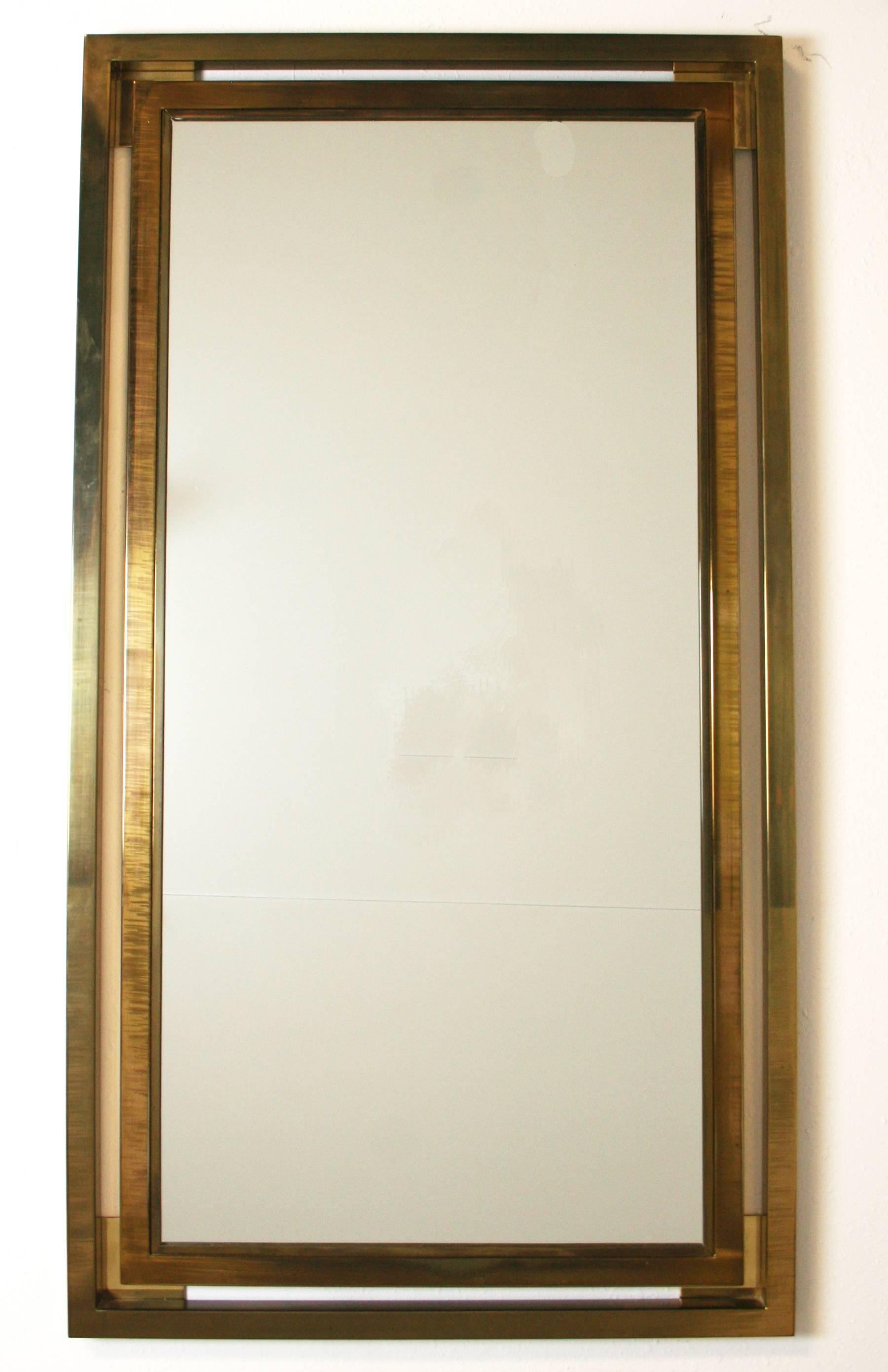 A 1970s Italian brass mirror, with two square section brass frames, one floating outside the other. in the style of Guy Lefevre or Wily Rizzo. Lovely patina to brass, but can be polished to a high shine. 