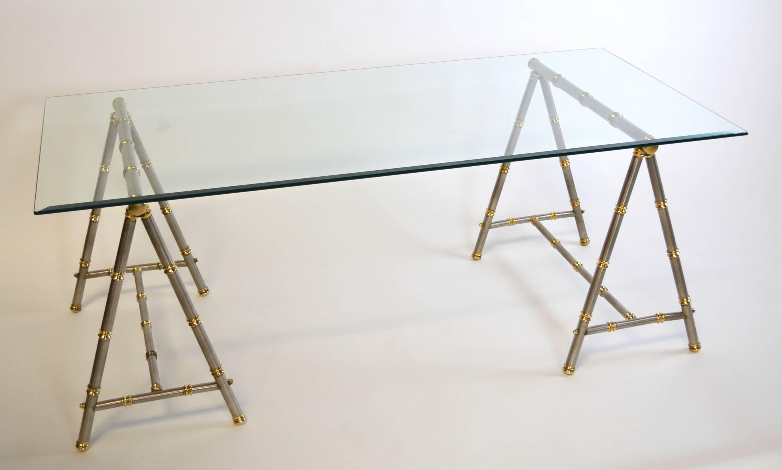 A chic pair of steel trestle or sawhorse form coffee table bases with brass accents. Stylized faux bamboo after Maison Jansen and Maison Charles, stamped 