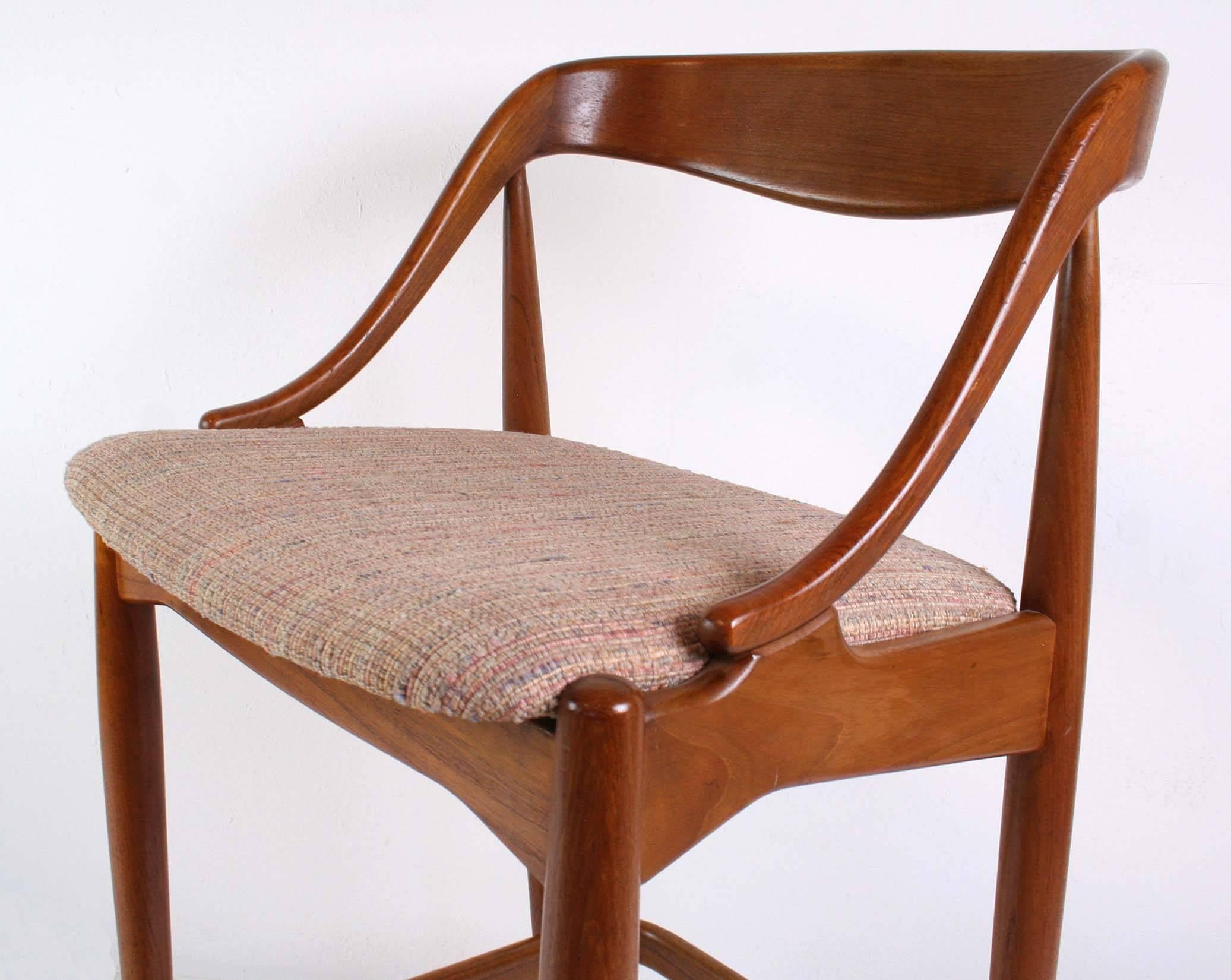 A set of three vintage Danish modern bar stools in oiled teak with a sculptural back similar in style to chairs by Niels Moller. Upholstered seats in good vintage as found condition.