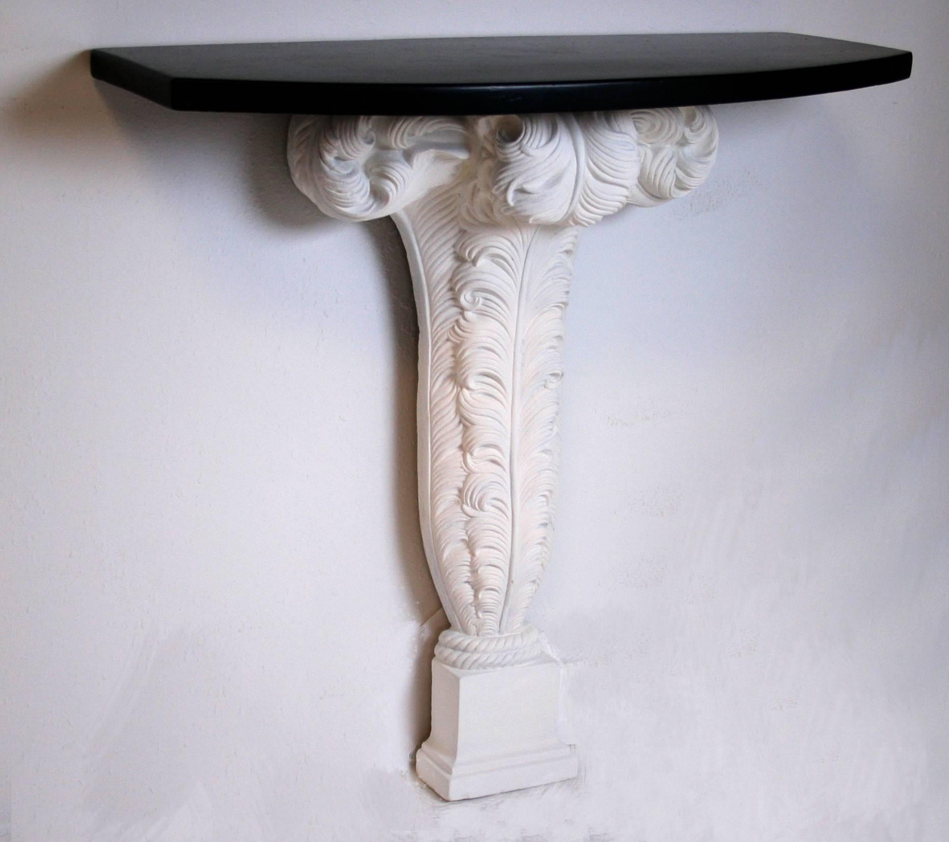 Pair of French wall-mounted plaster console tables with feather-form bases and new ebonized wood tops. By Maison Jansen, France, 1940s. Plaster bases 34.875