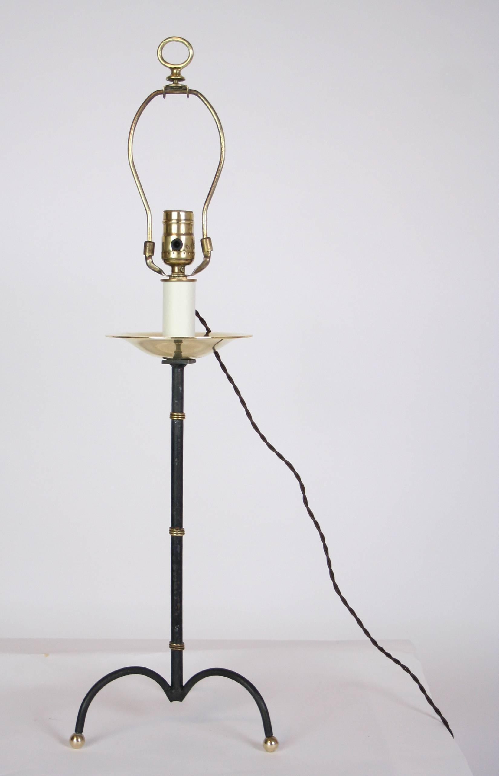 A Jacques Adnet lamp newly created from an astray. Wrought metal tripod base and shaft with brass accents and a brass bowl repurposed as a lamp. French wired with twisted cloth cord. Shade for display only. 