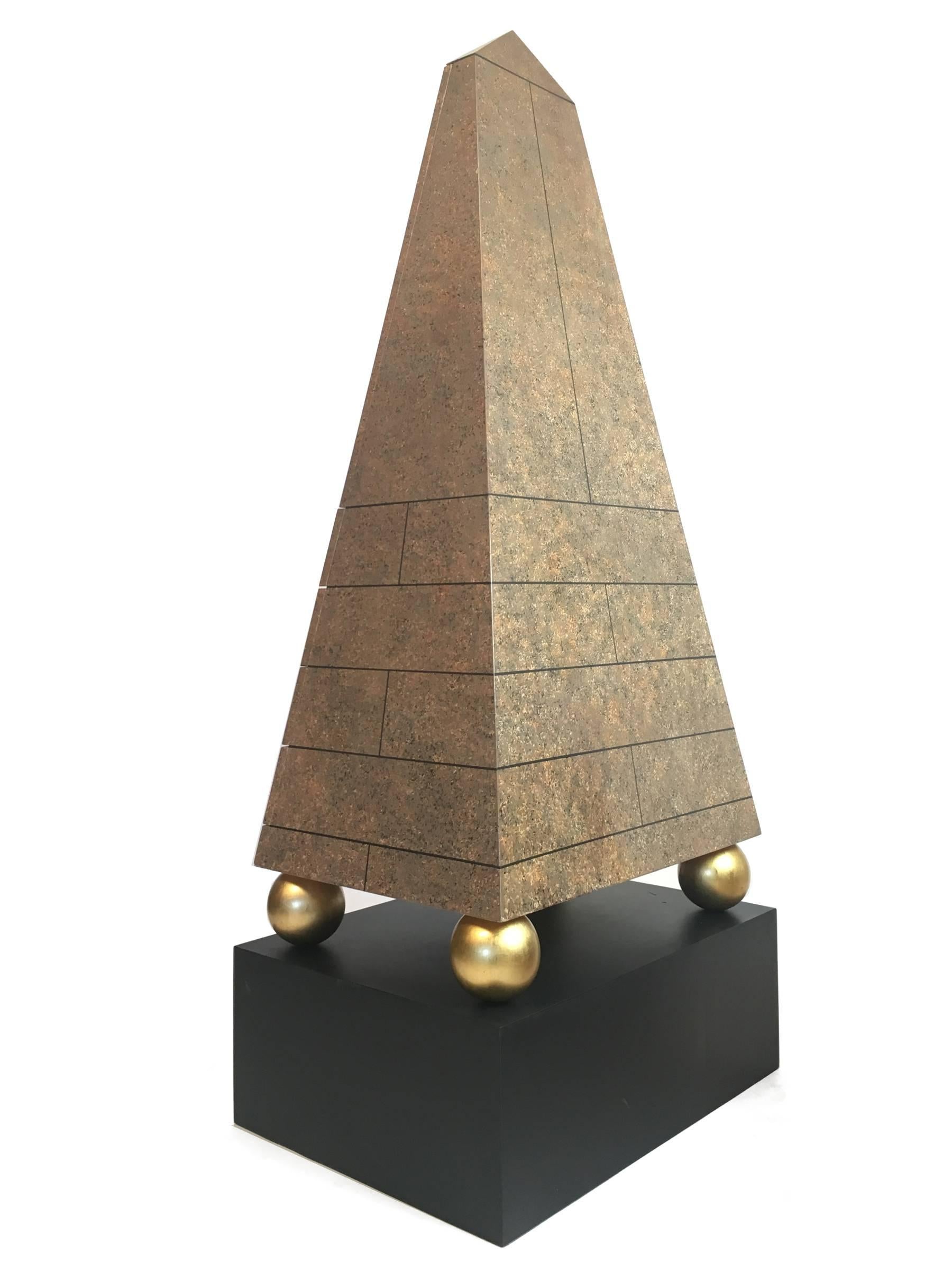 A truly unique pair of Post-Modernist cabinets in the form of a faux porphyry obelisk or pyramid on four gilded balls, resting on a black plinth base. Each cabinet contains four drawers under an upper cabinet with two doors. The piece is finished on