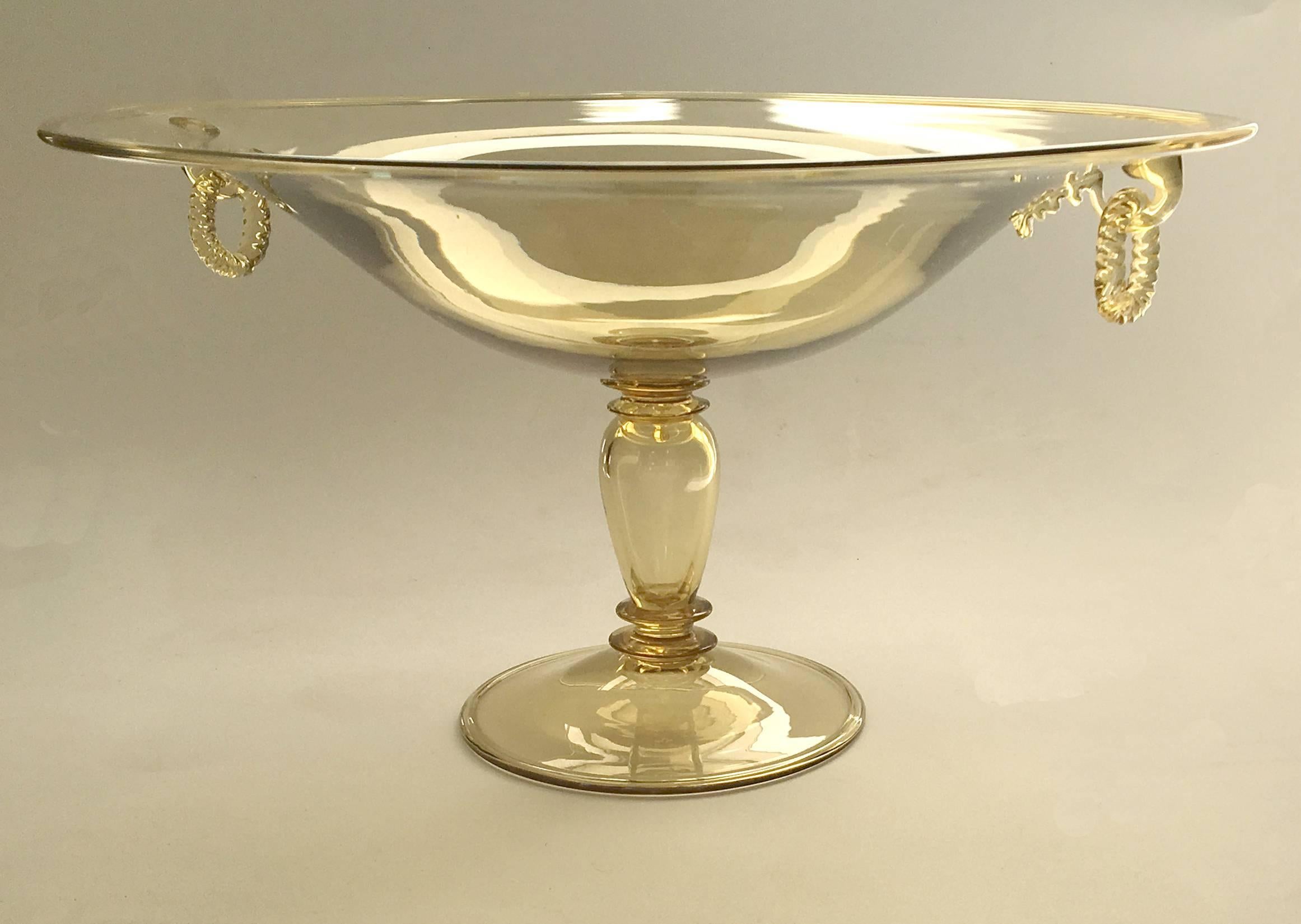 An early Steuben glass shallow bowl, with original twist rope glass ring handles, on pedestal. elegant light citrine color. Rare and unusual with the same color handles. Unmarked.