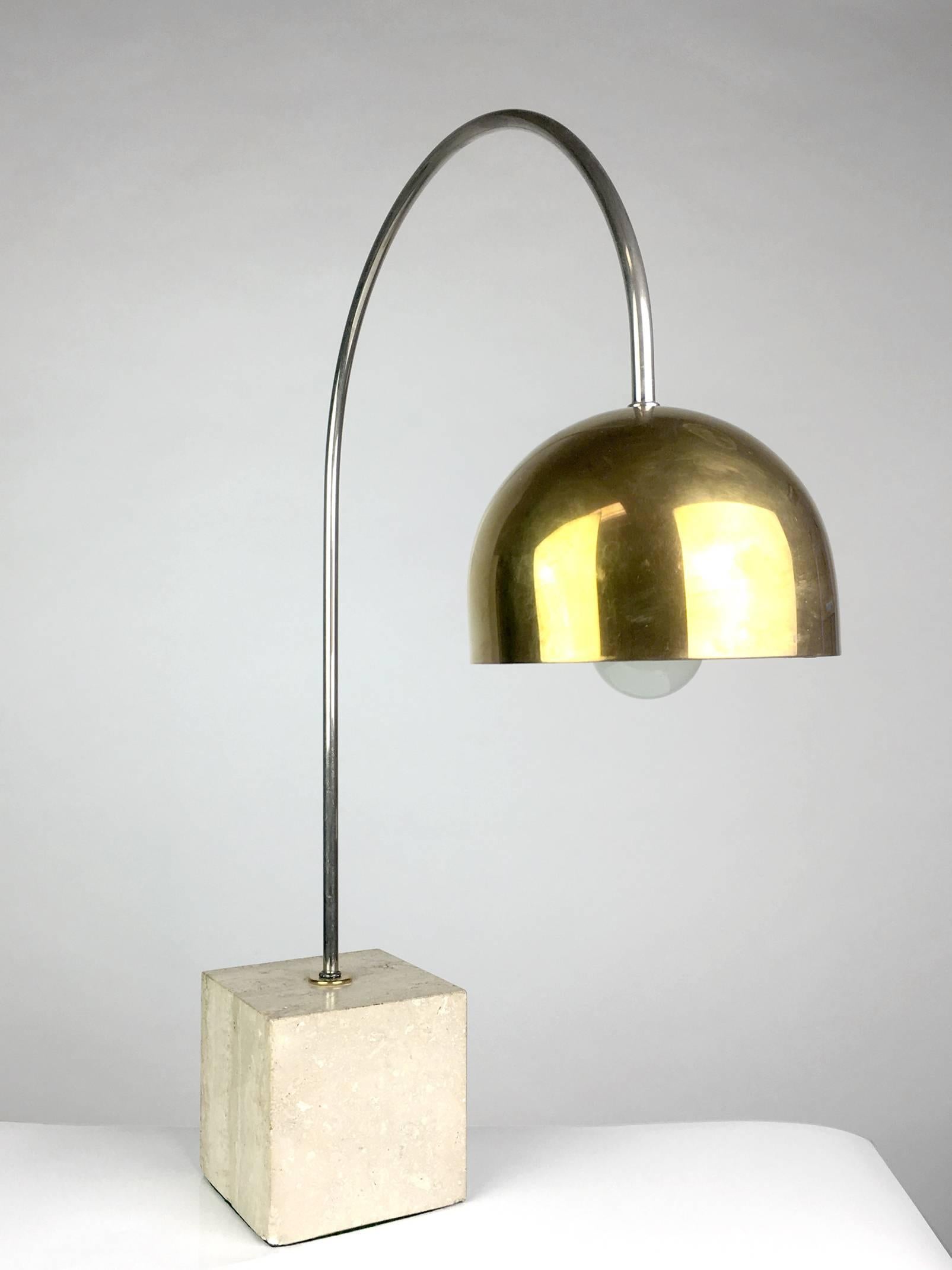 Chic brass, chrome and travertine desk lamp by Guzzini. Chrome arc with brass dome shade anchored by a travertine cube. Base is 5" x 5" x 5".
 