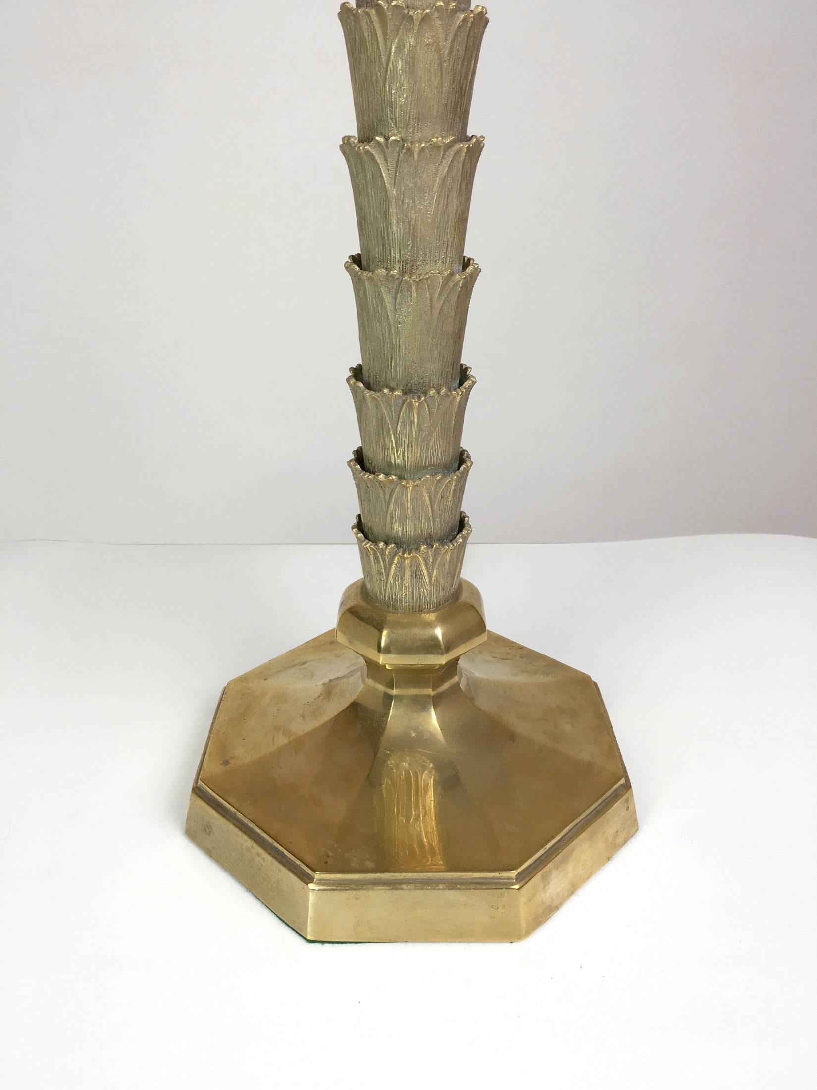 A stylish bronze palm tree trunk lamp. The bronze fluted tiered trunk on an octagonal base. Substantial and well made. Newly retired with new double sockets. Measures: Height to top of trunk, 20". Shade for display only.
