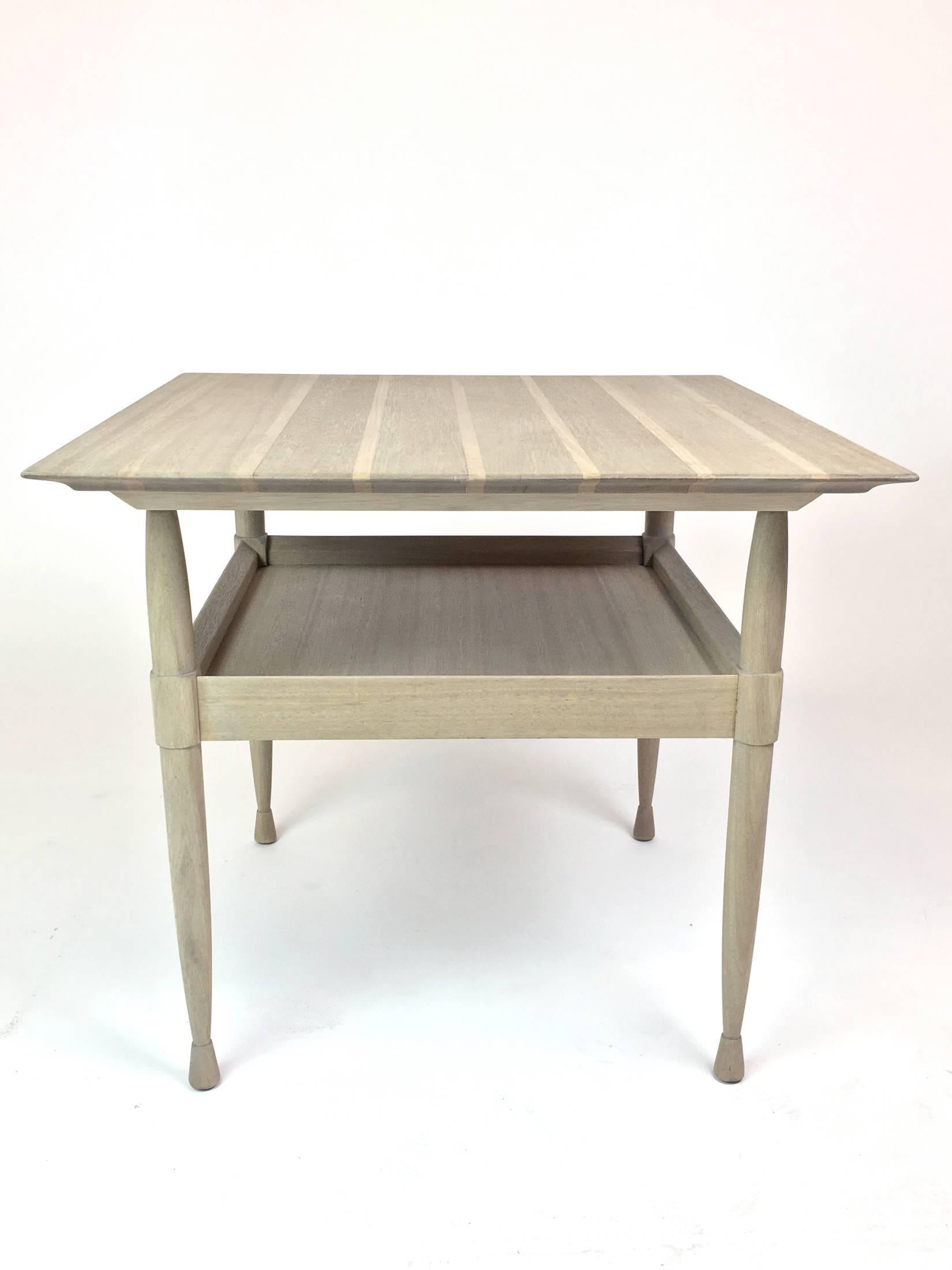 A silver grey finished mahogany side table with tray shelf. The top is striped in two tones of wood, and is supported on turned legs.