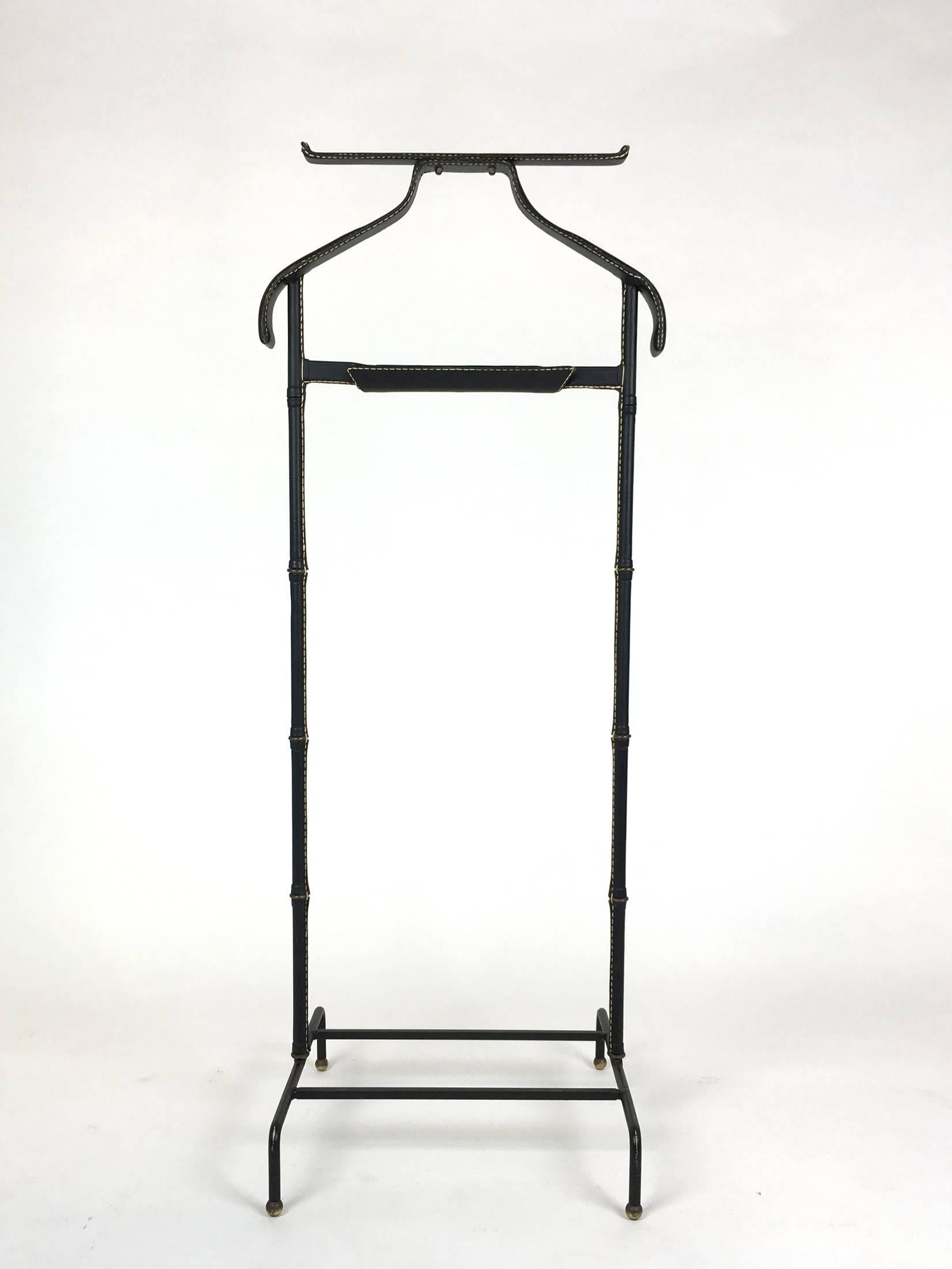 A good leather wrapped valet stand by Jacques Adnet. Iron frame wrapped in black leather with contrast stitching and brass accents. Leather is in very good condition.