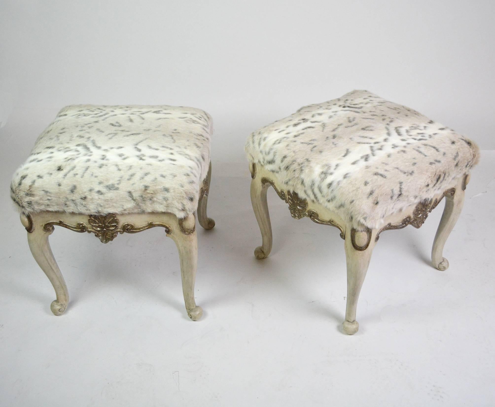 A pair of early 20th century Chippendale stools, with and antiqued paint finish and silver leafed details. Recently re-upholstered in Sahco faux fur.