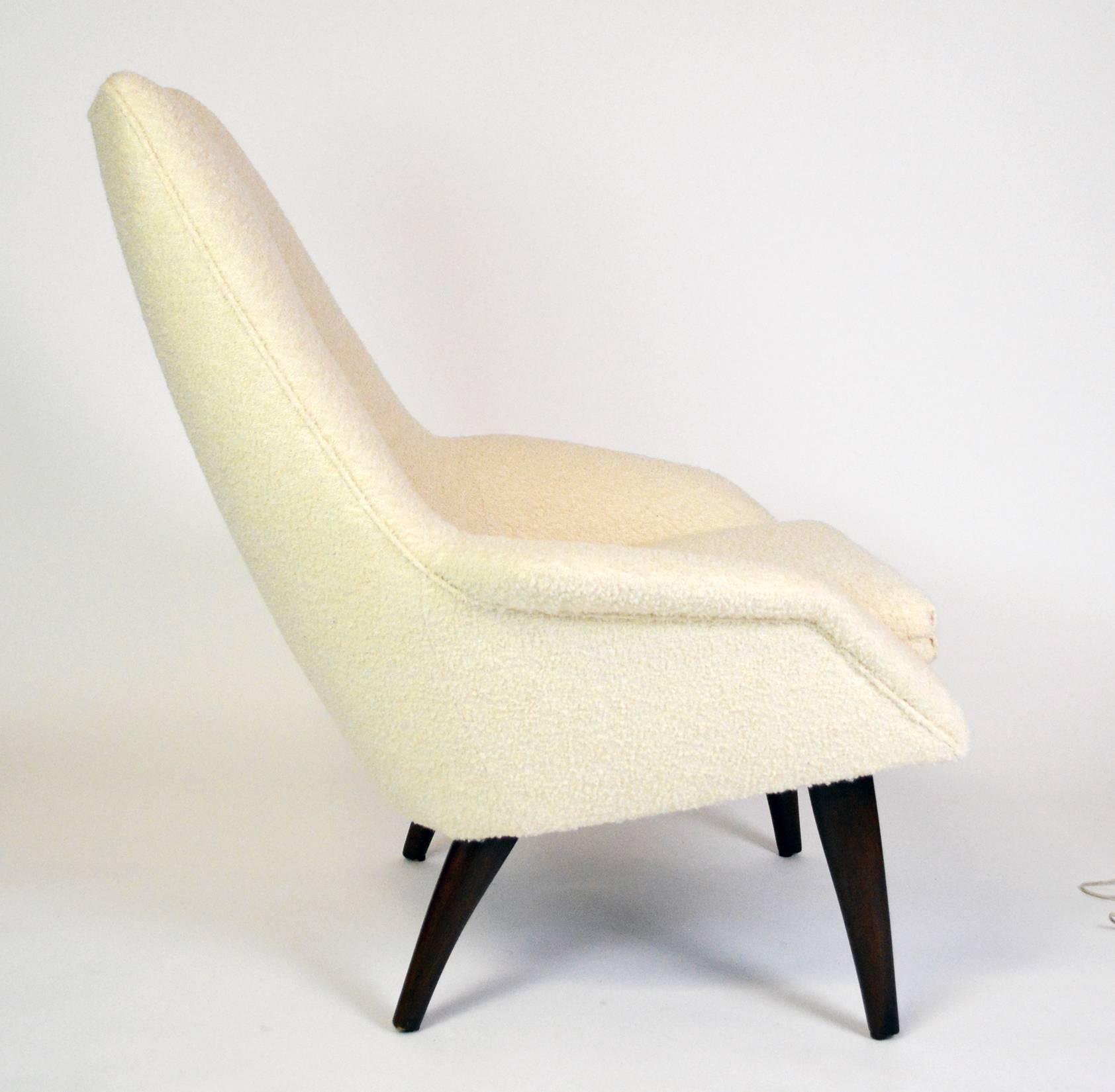 A sculptural Danish lounge chair with a loose seat cushion and tufted back, on curved, tapered walnut legs. Arm height 20" at front,
seat height 18"
seat depth, 21"
seat width, 19".