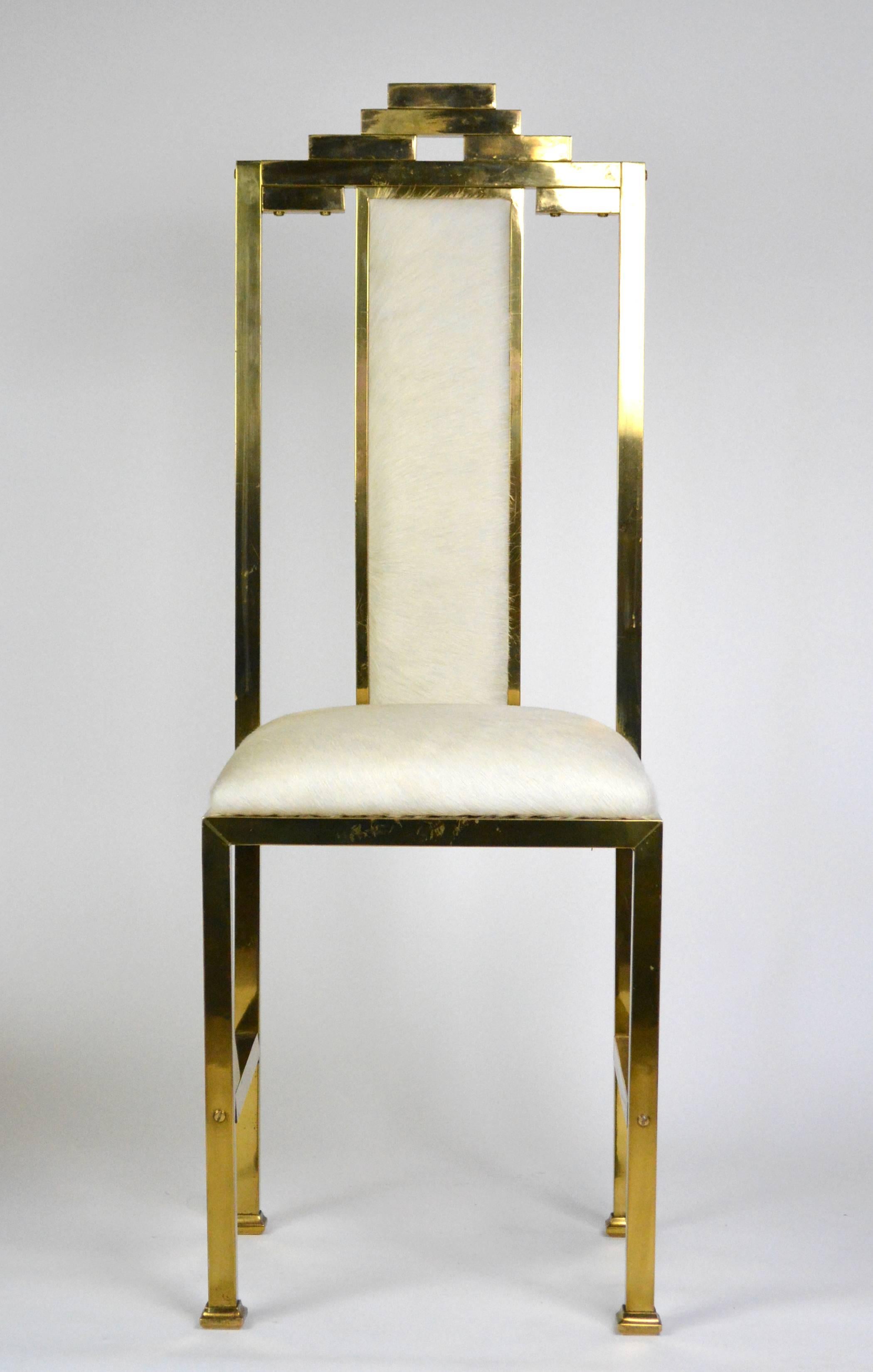 Four skyscraper style brass chairs with new hair-on-hide upholstery. Circa 1970's, with an Art Deco, Hollywood Regency feel.